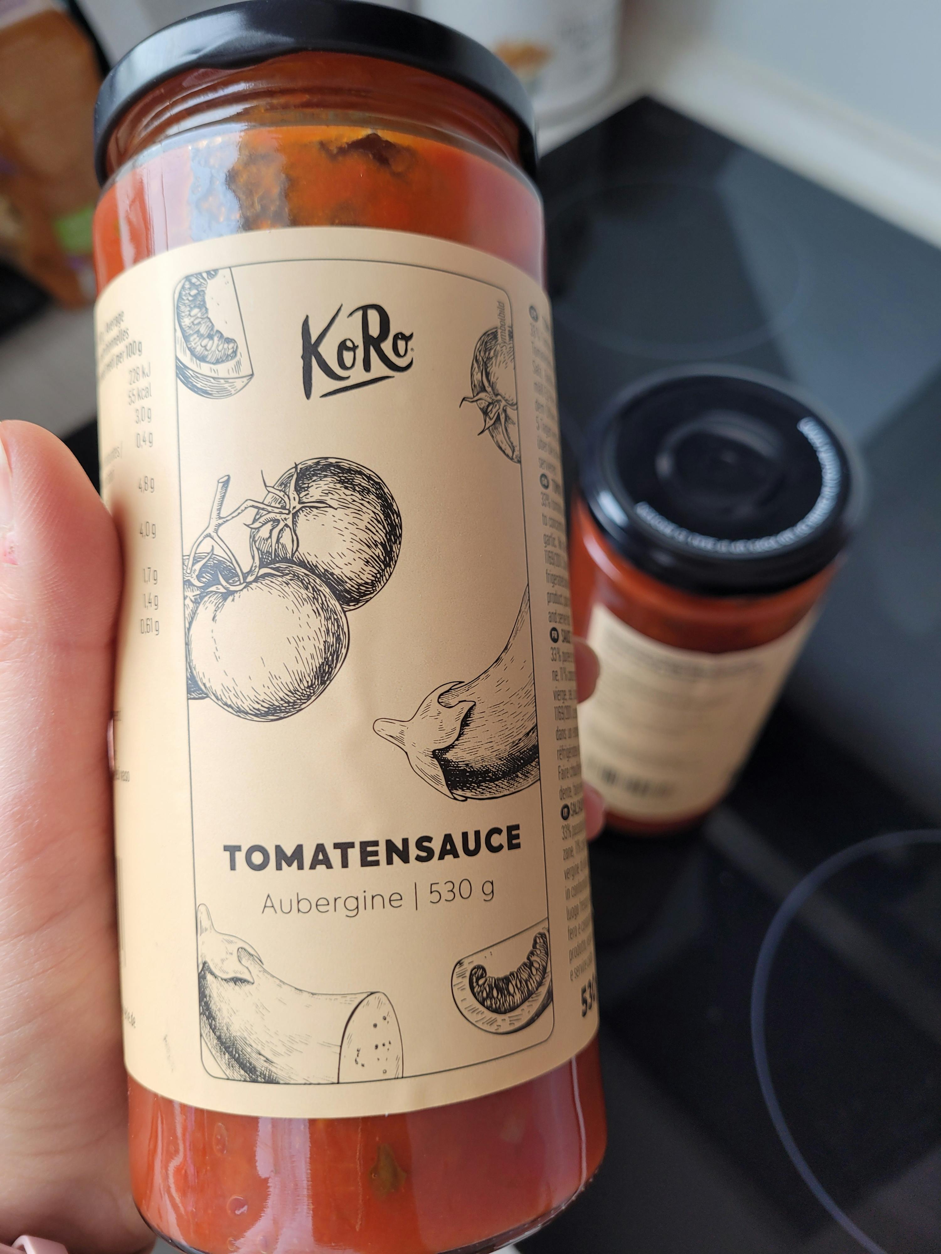 une personne tient un pot de sauce tomates aubergine