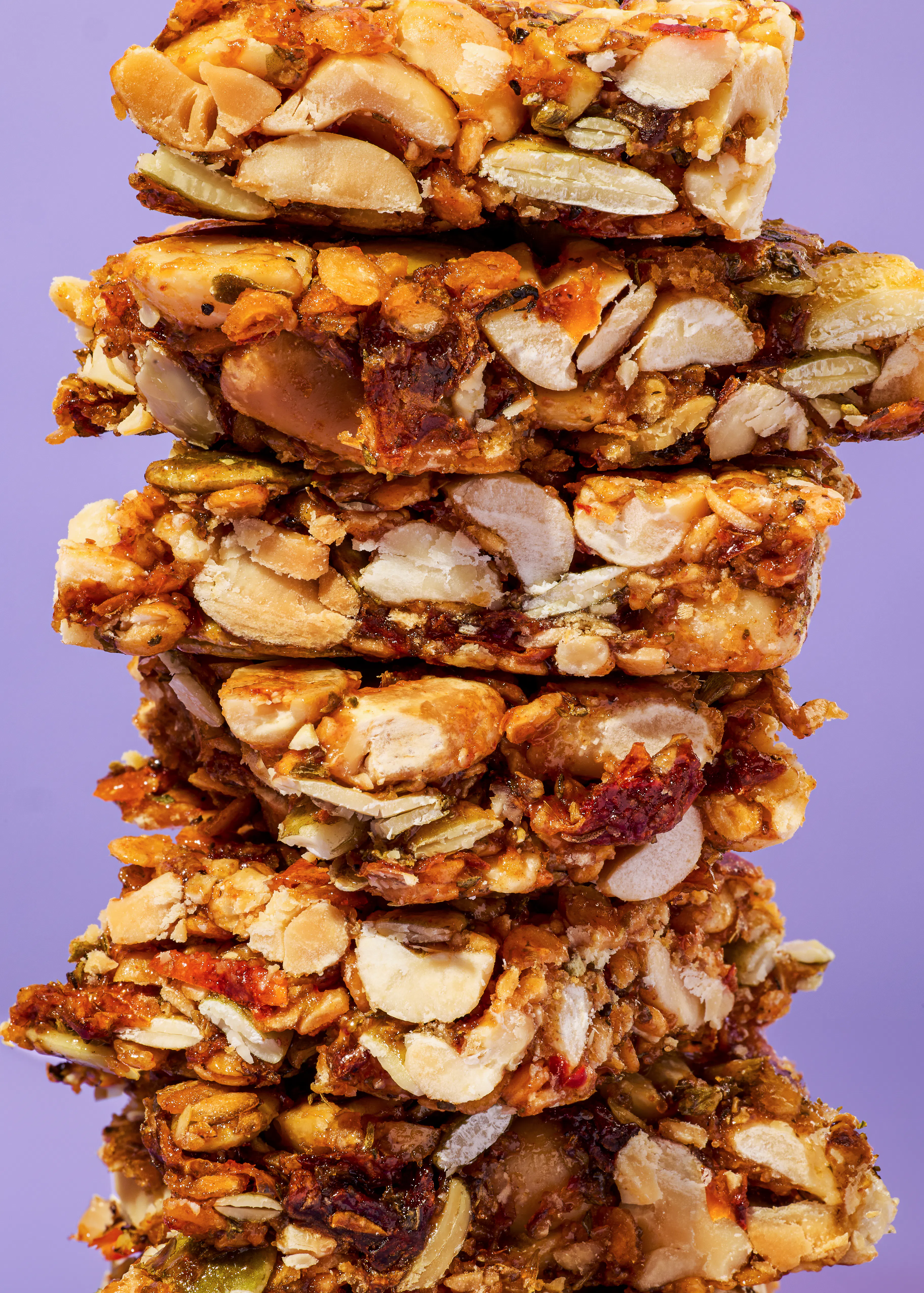 des barres de granola empilées les unes sur les autres sur fond violet