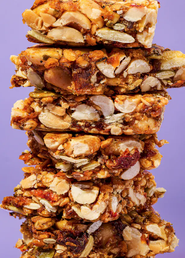 des barres de granola empilées les unes sur les autres sur fond violet