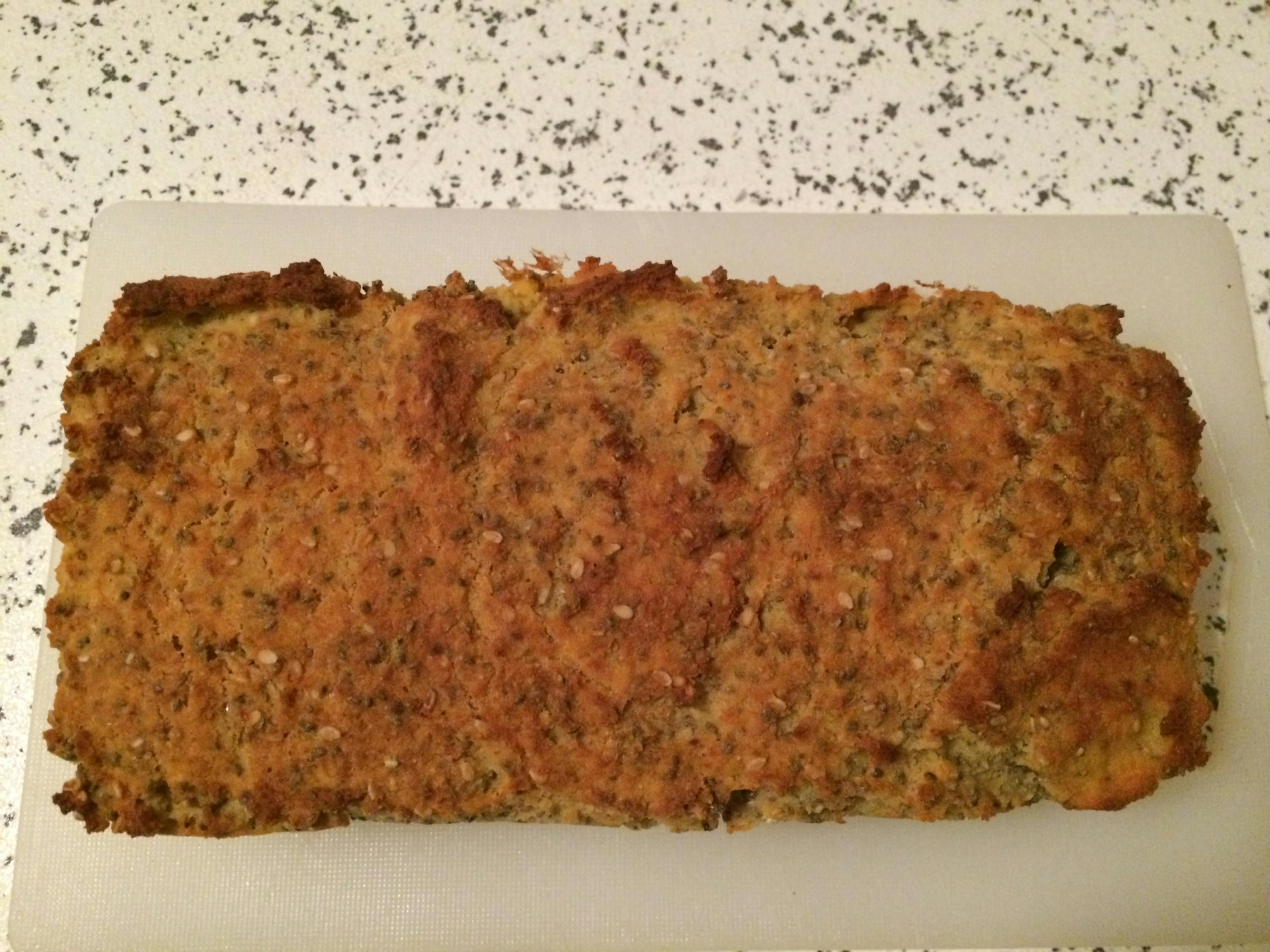 a loaf of bread sits on a white cutting board
