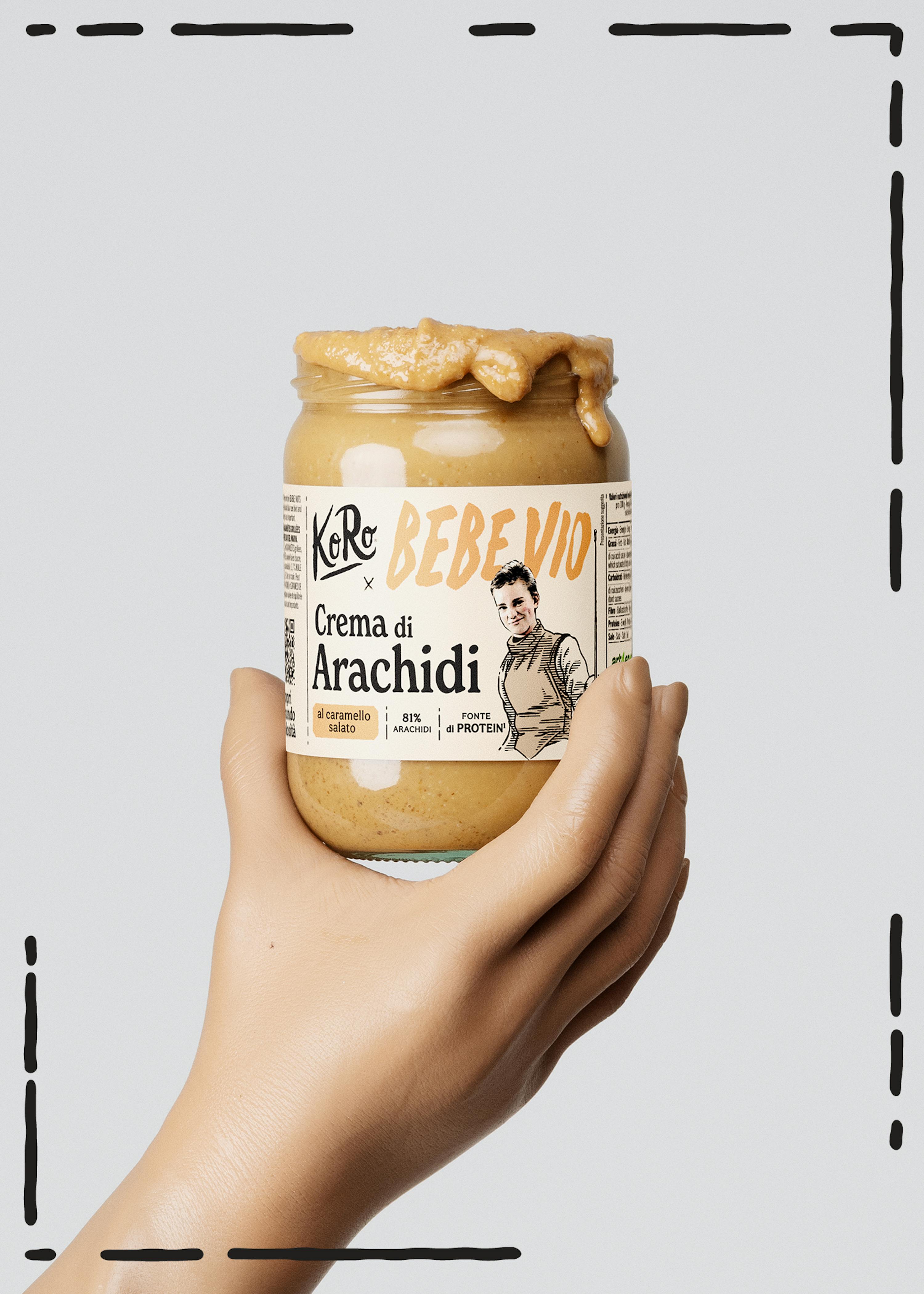 una mano tiene in mano un barattolo di crema di arachidi