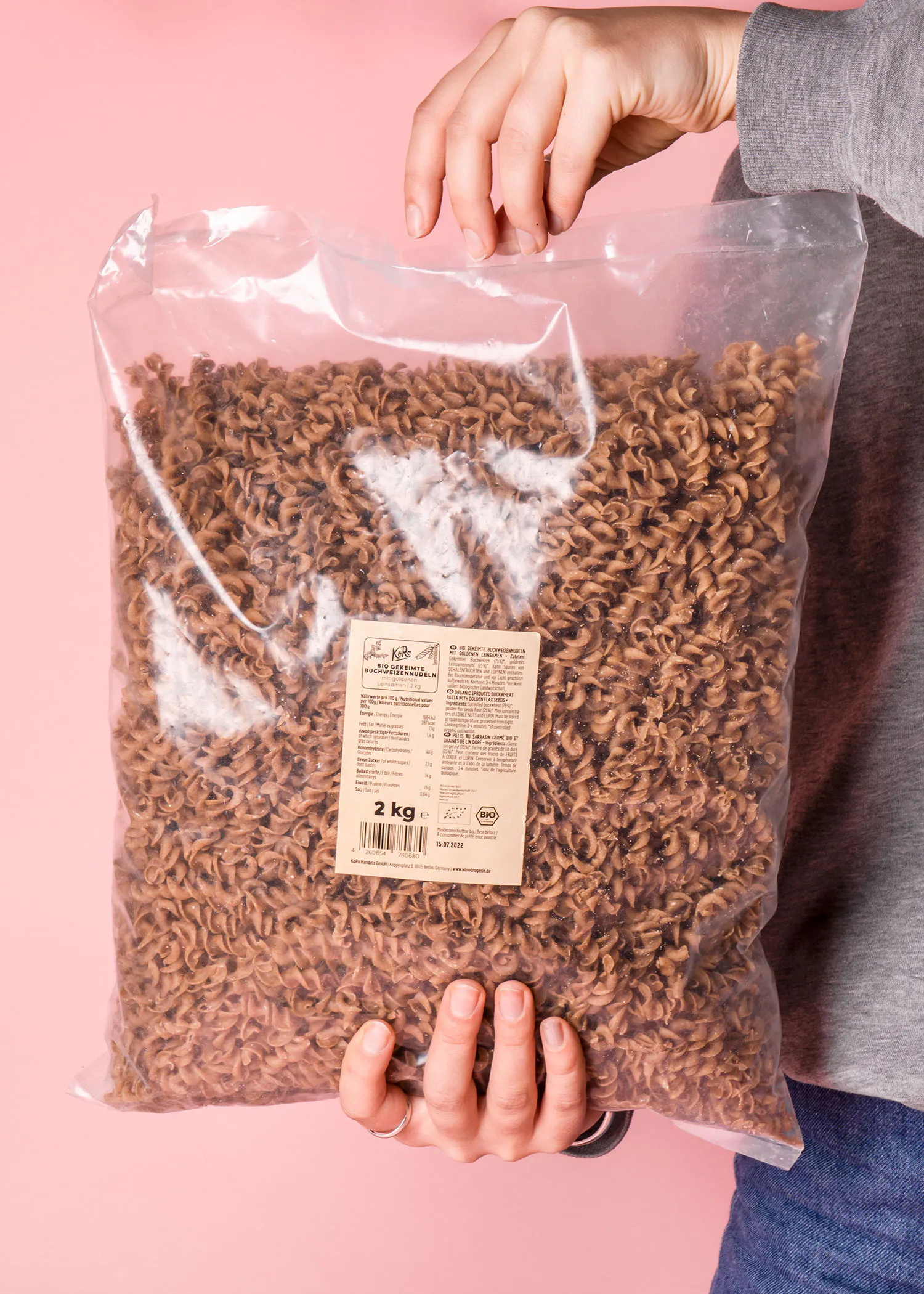 eine Person hält einen Plastiksack mit Nudeln in der Hand