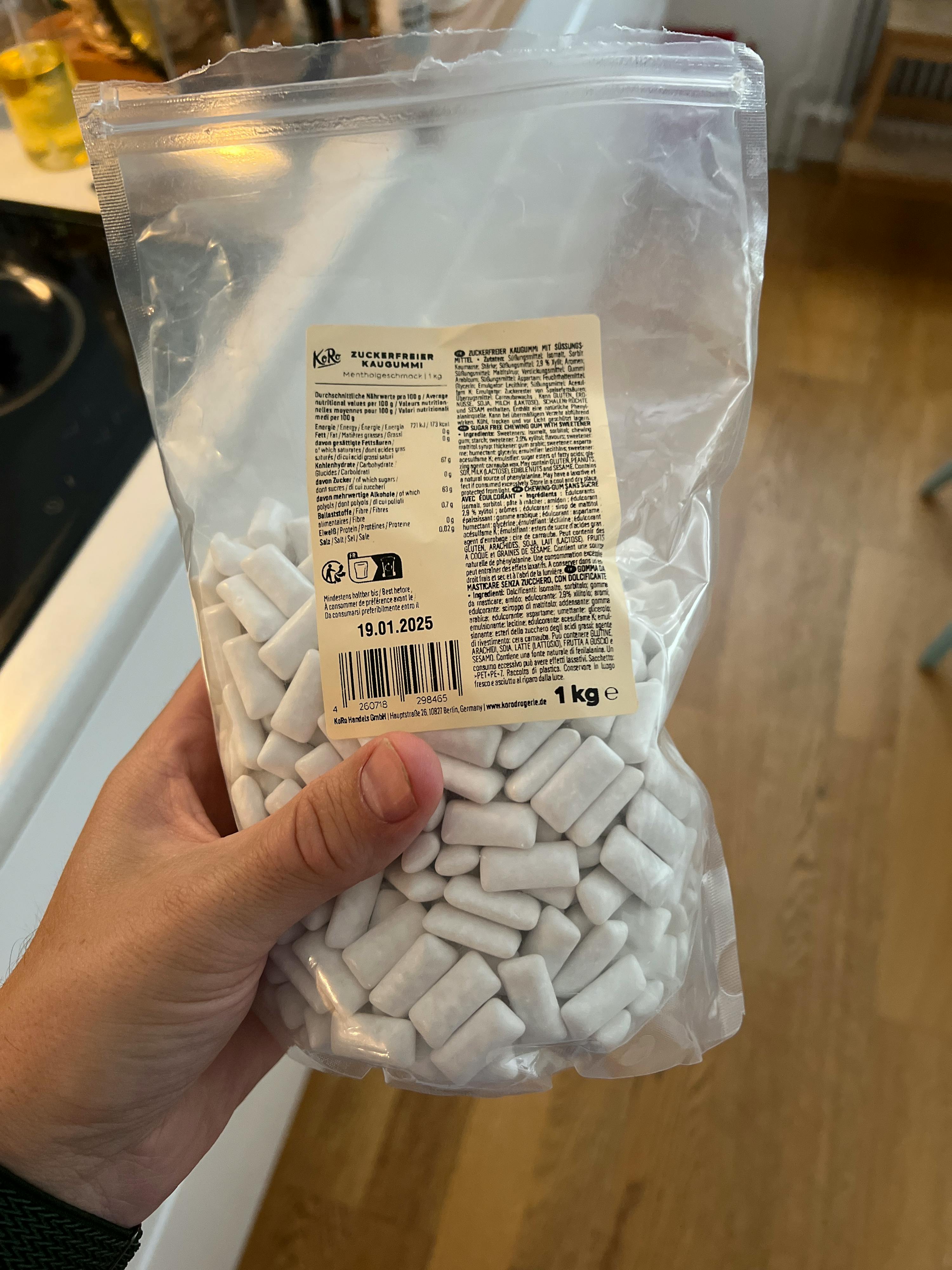 una persona tiene in mano un sacchetto di gomme da masticare bianche