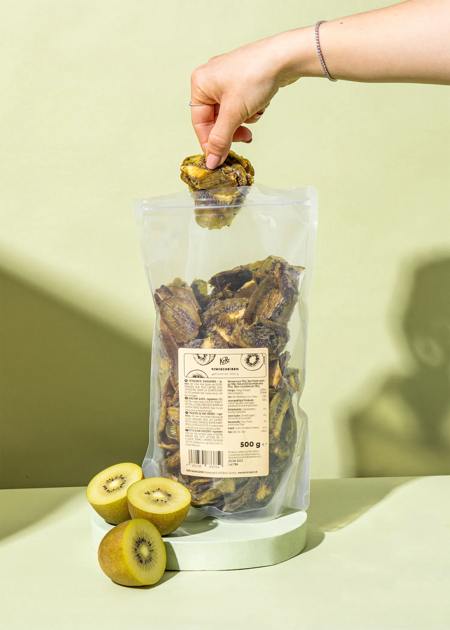 a person is holding a bag of dried kiwi fruit