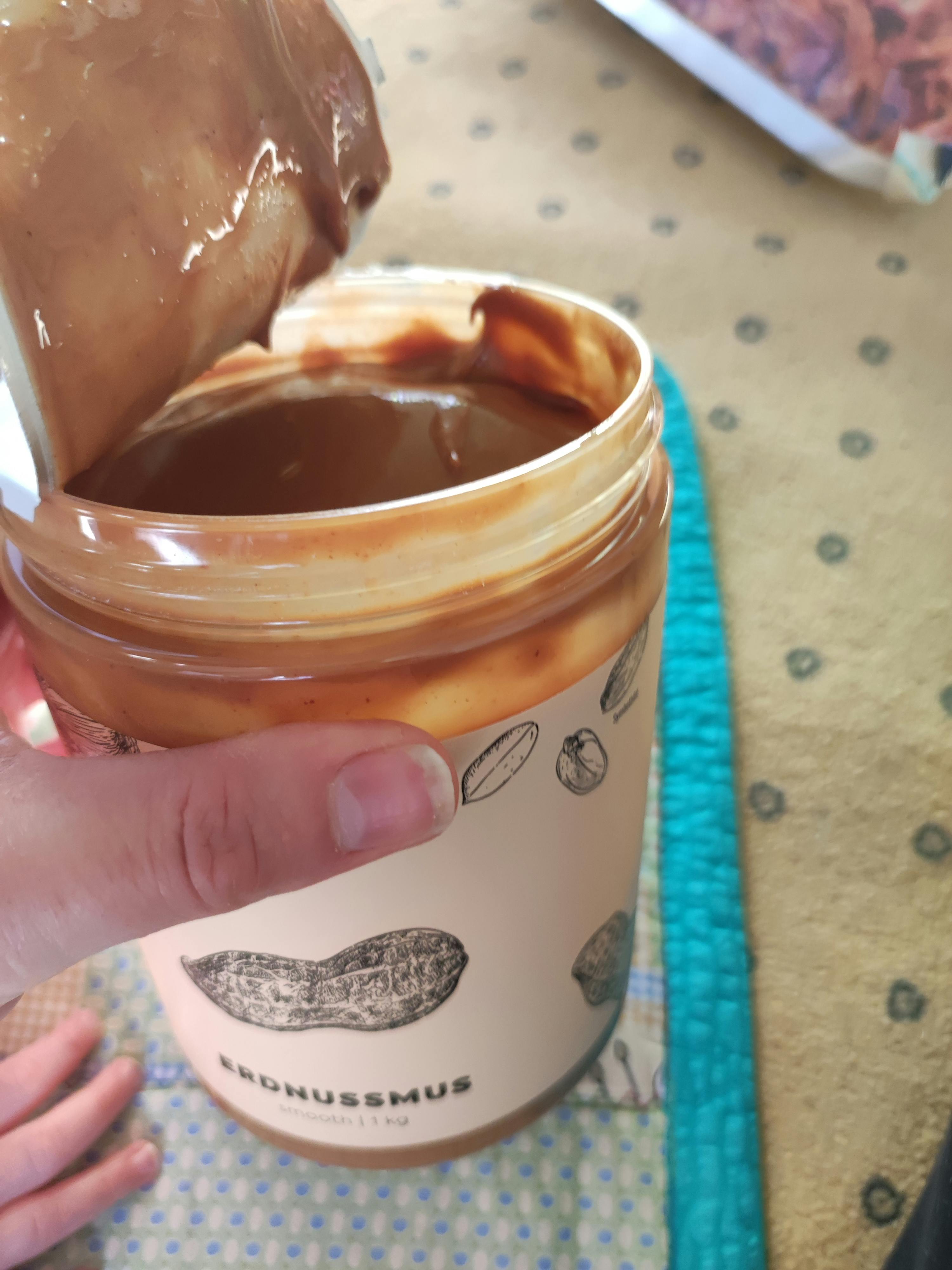 a person is holding a jar of peanut butter