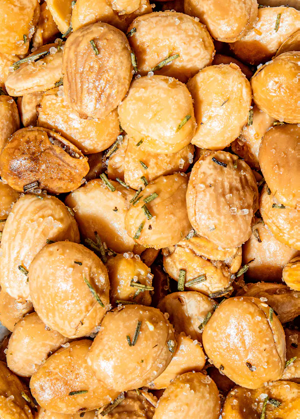 a close up of a pile of almonds with rosemary