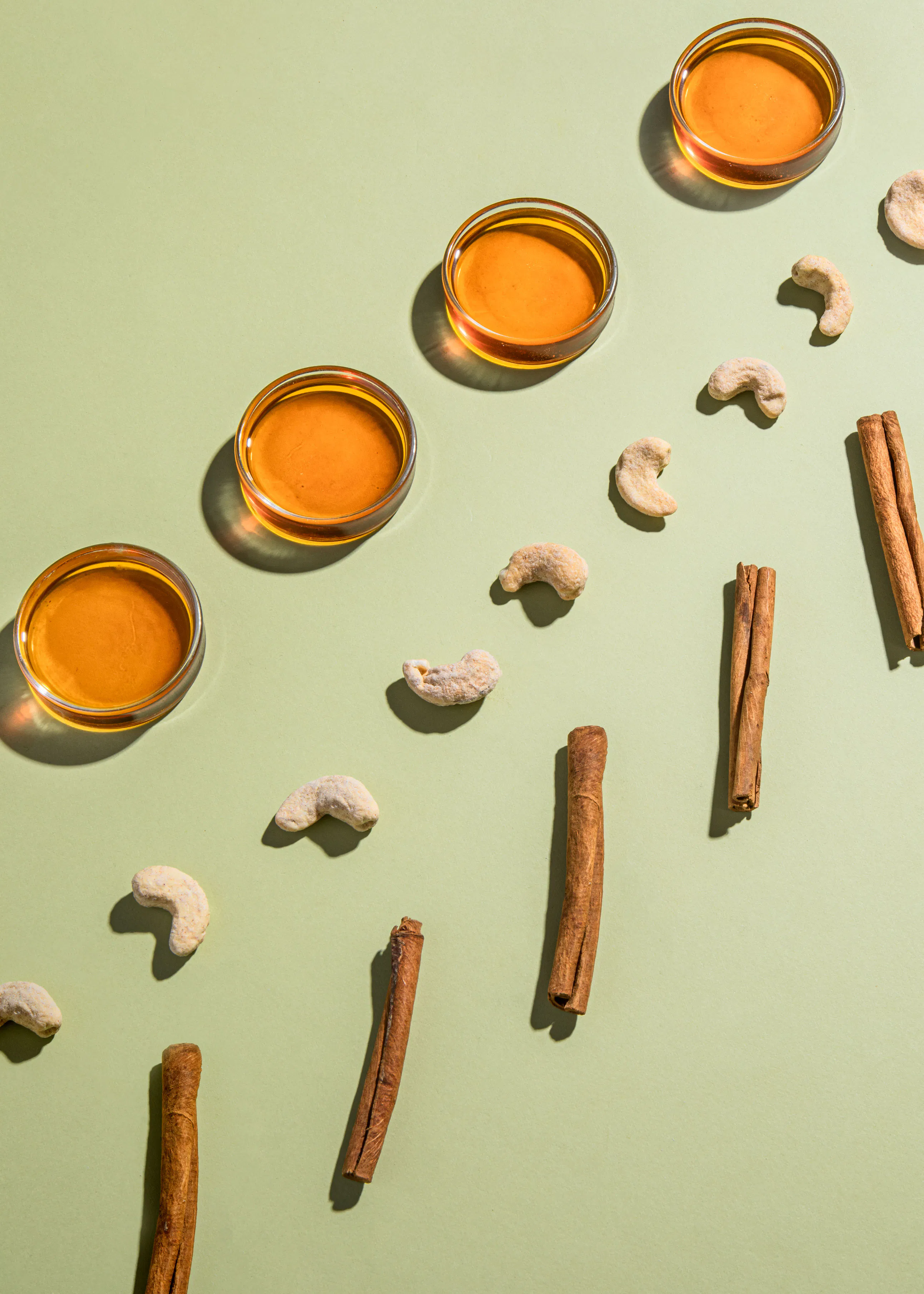 nuts and cinnamon sticks are arranged on a green surface