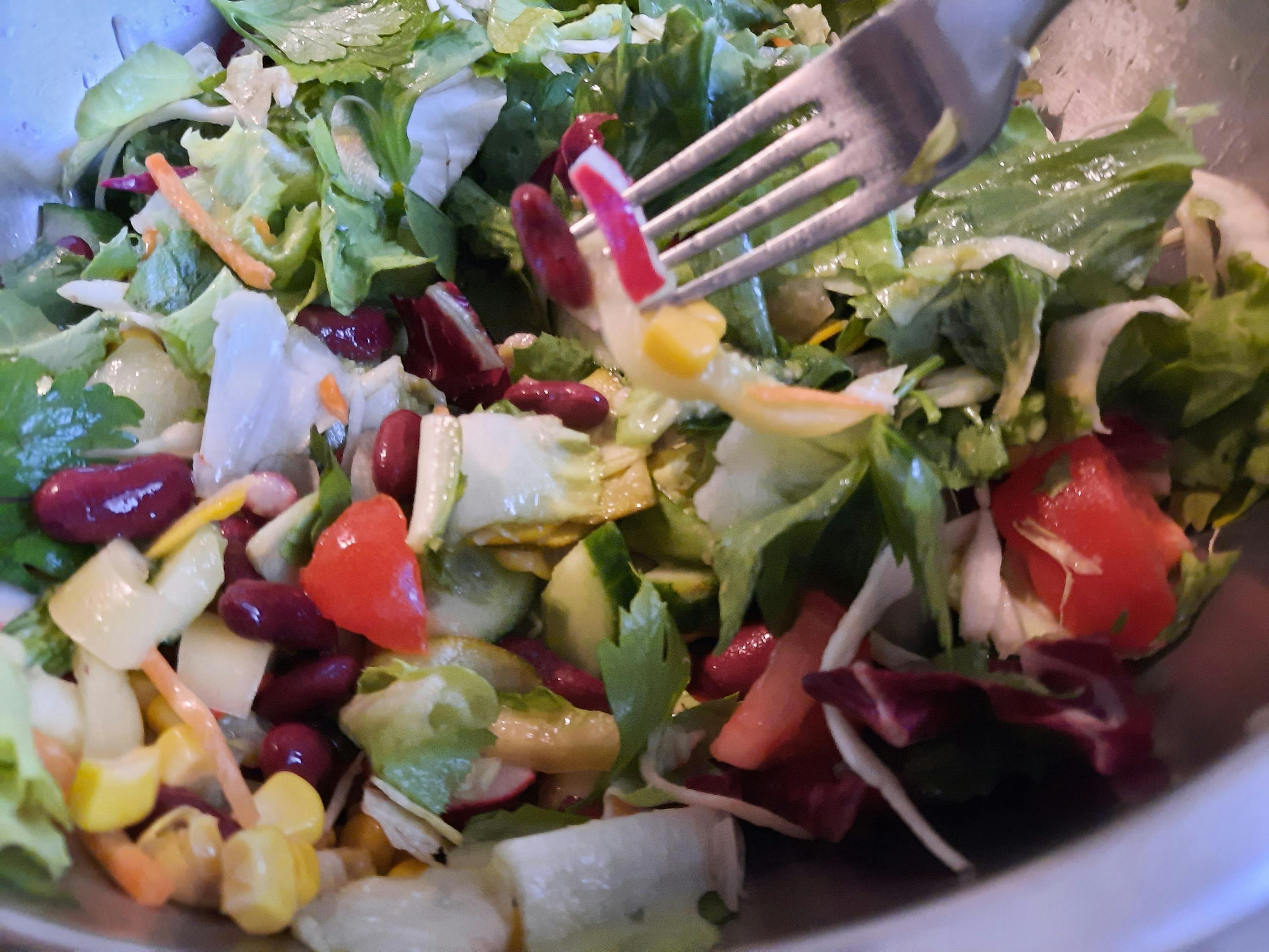 un gros plan d' une salade avec des haricots rouges et des tomates