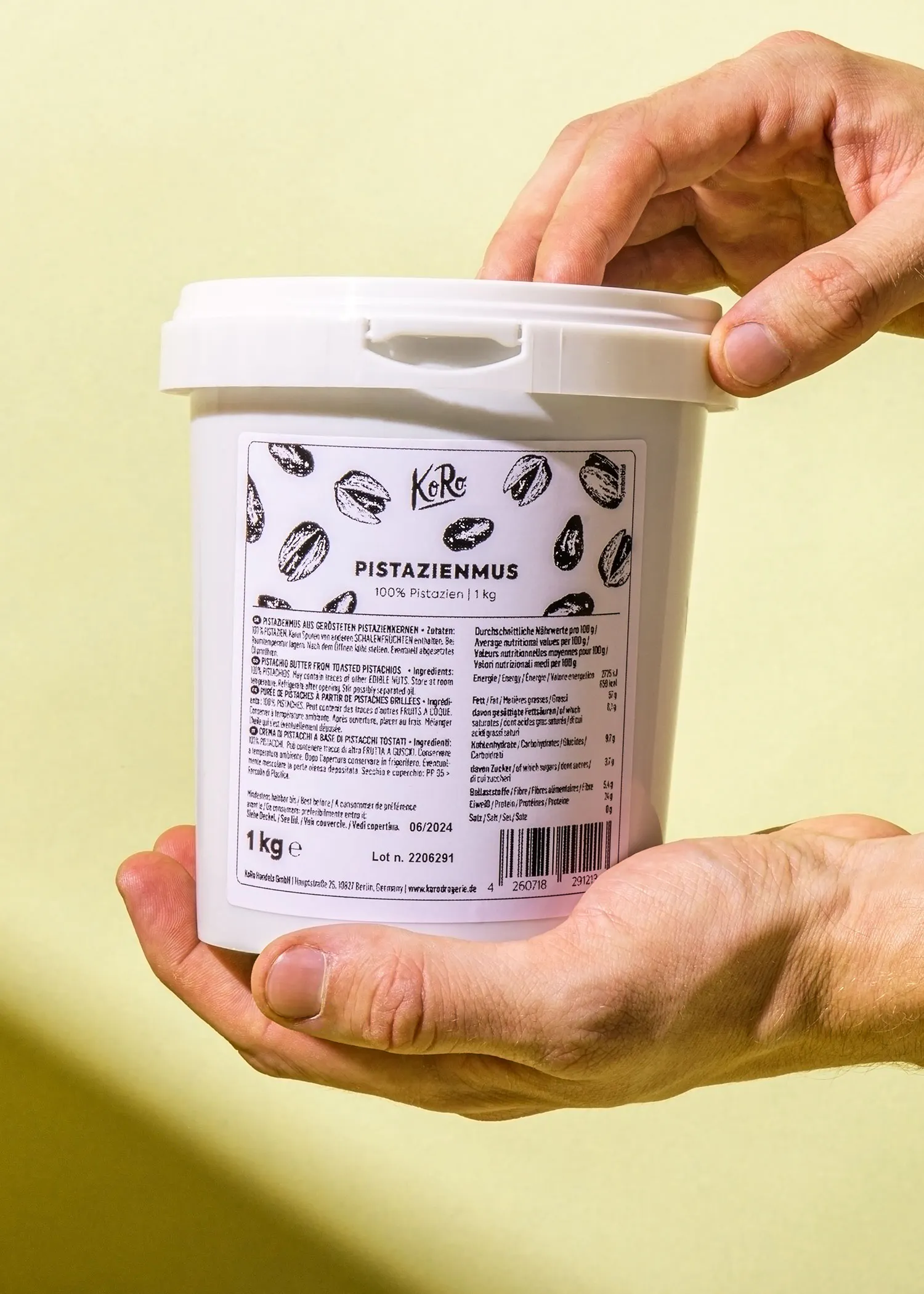 une personne tient un pot de pistazienmus à 1 kg