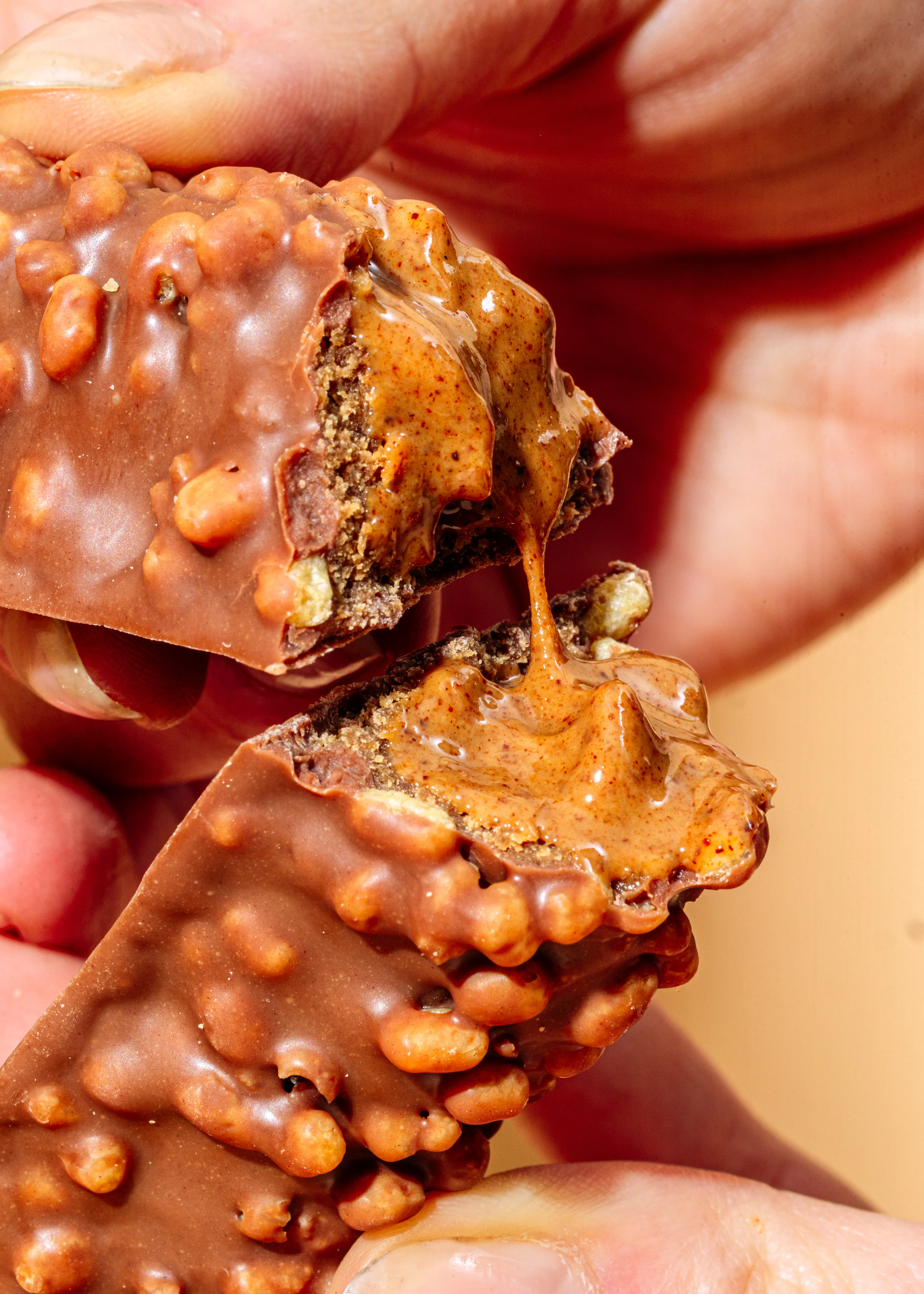 a person holding a chocolate bar with peanut butter on it