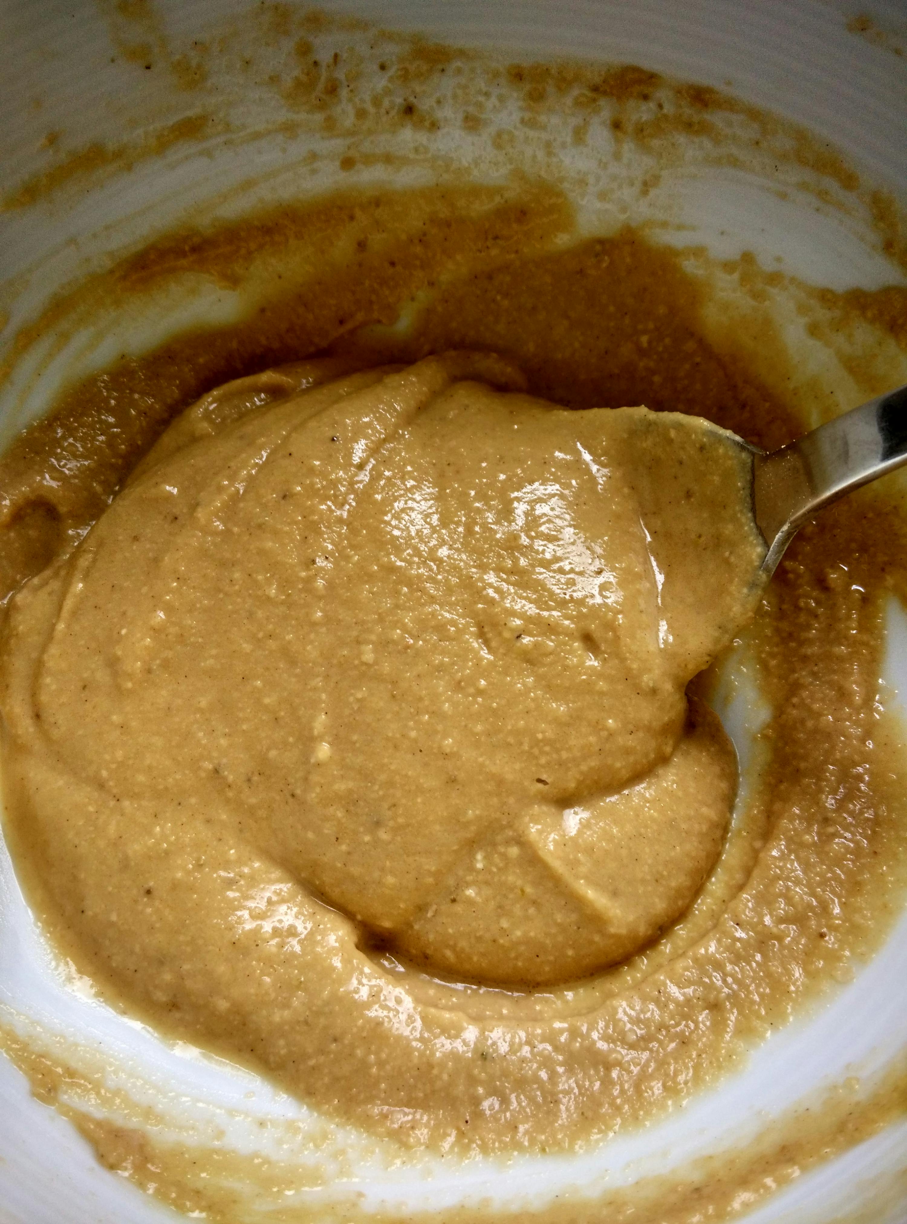 a close up of a spoon in a bowl of sauce