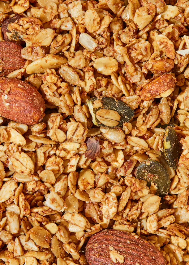 un gros plan d' un tas de granola avec des amandes et des graines de citrouille