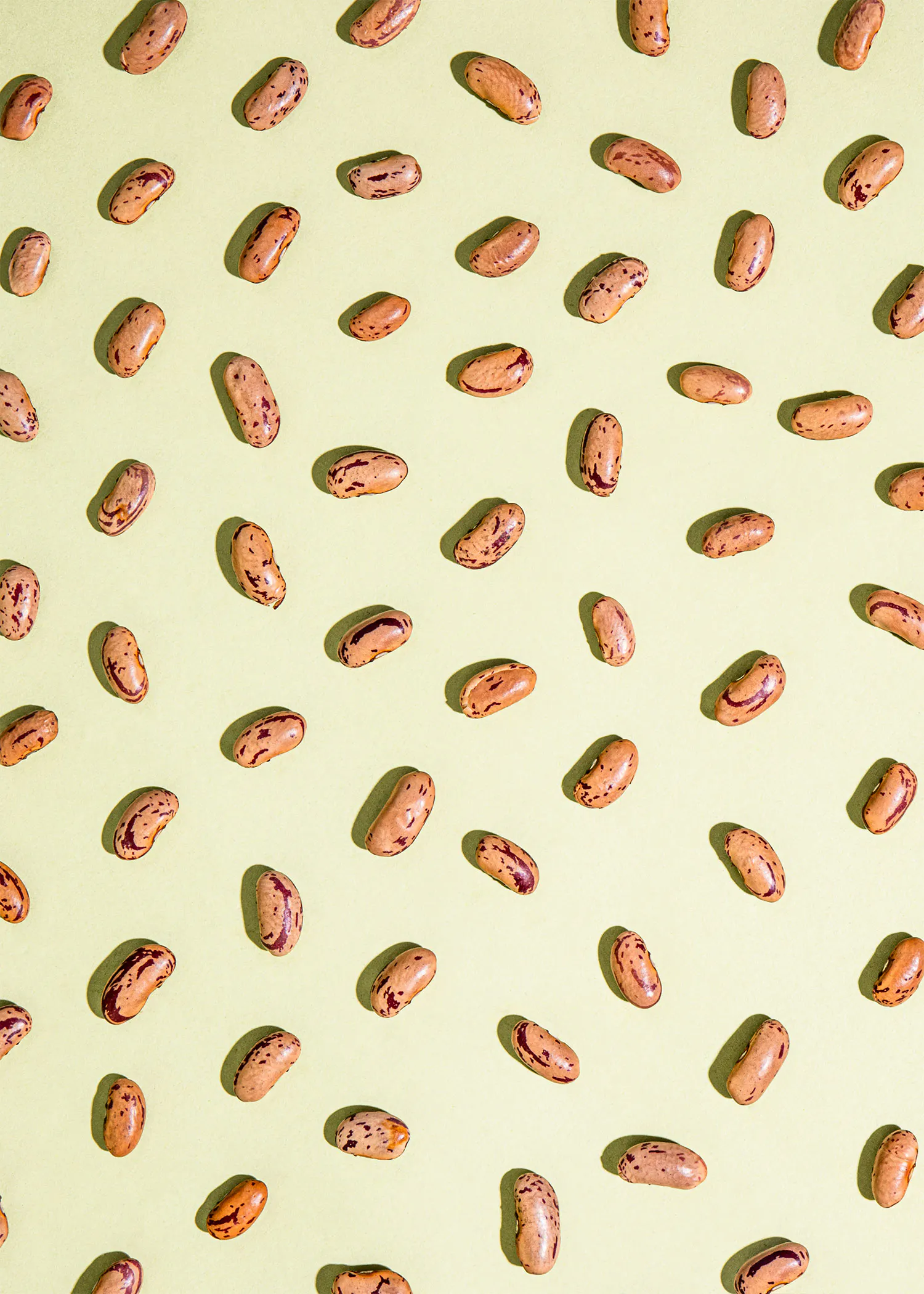 a pattern of brown beans on a yellow background