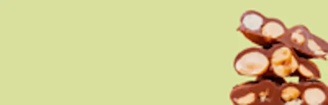 ein Stapel Schokoladenbonbons mit Erdnüssen auf einem grünen Hintergrund .