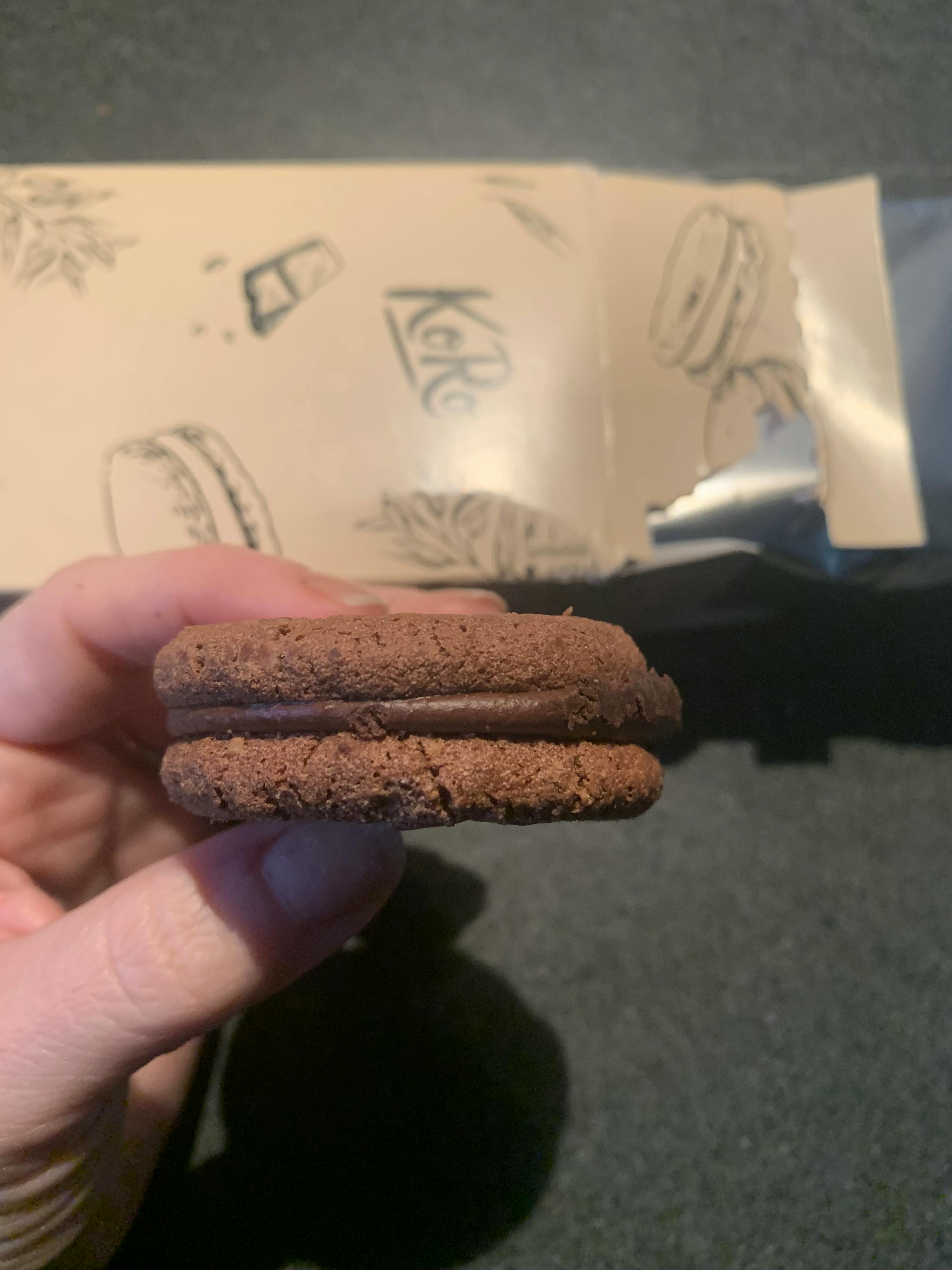 Eine Person hält ein Schokoladenkeks in der Hand