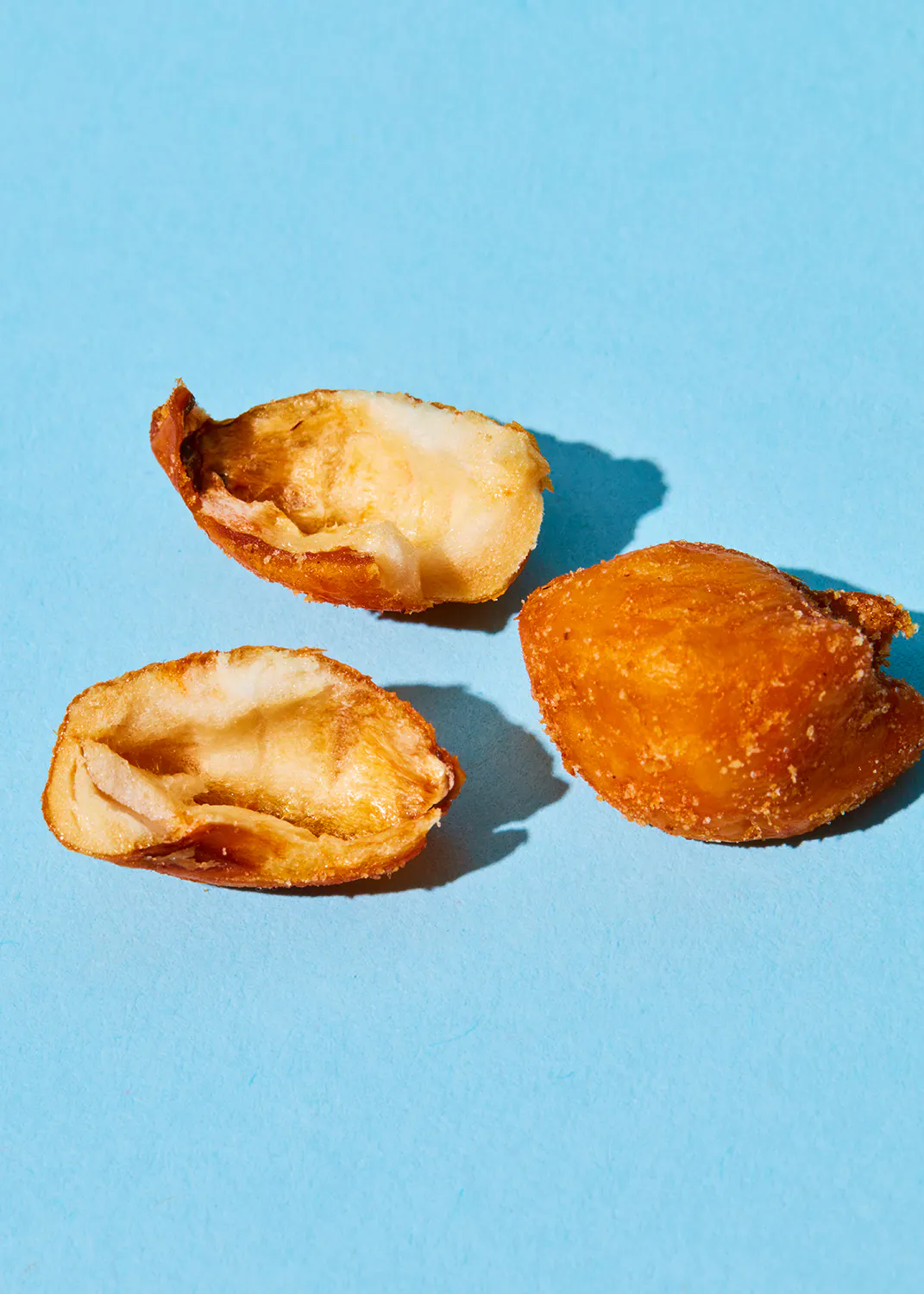 three pieces of fried food are on a blue surface