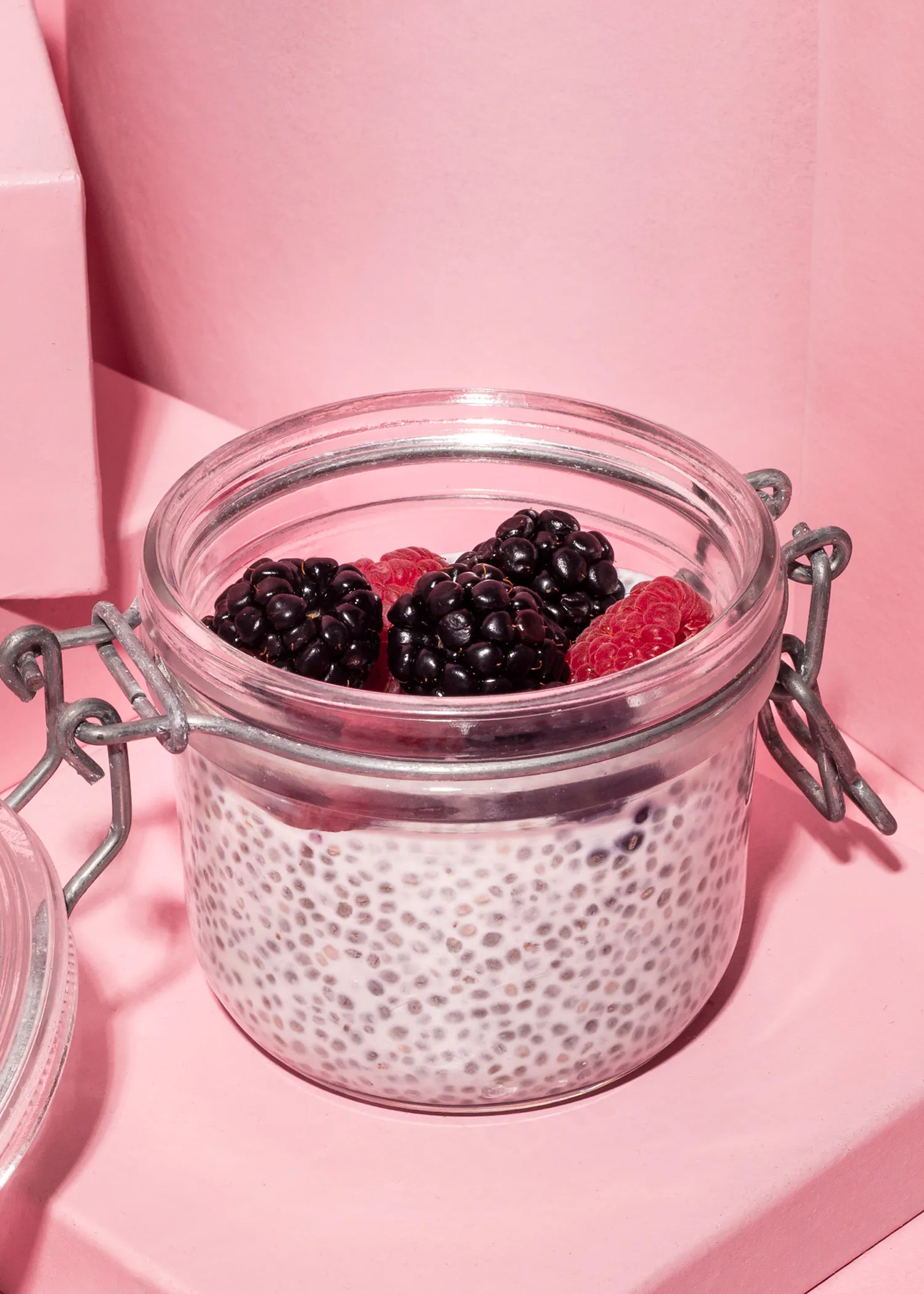 un bocal en verre rempli de chia seeds et de framboises