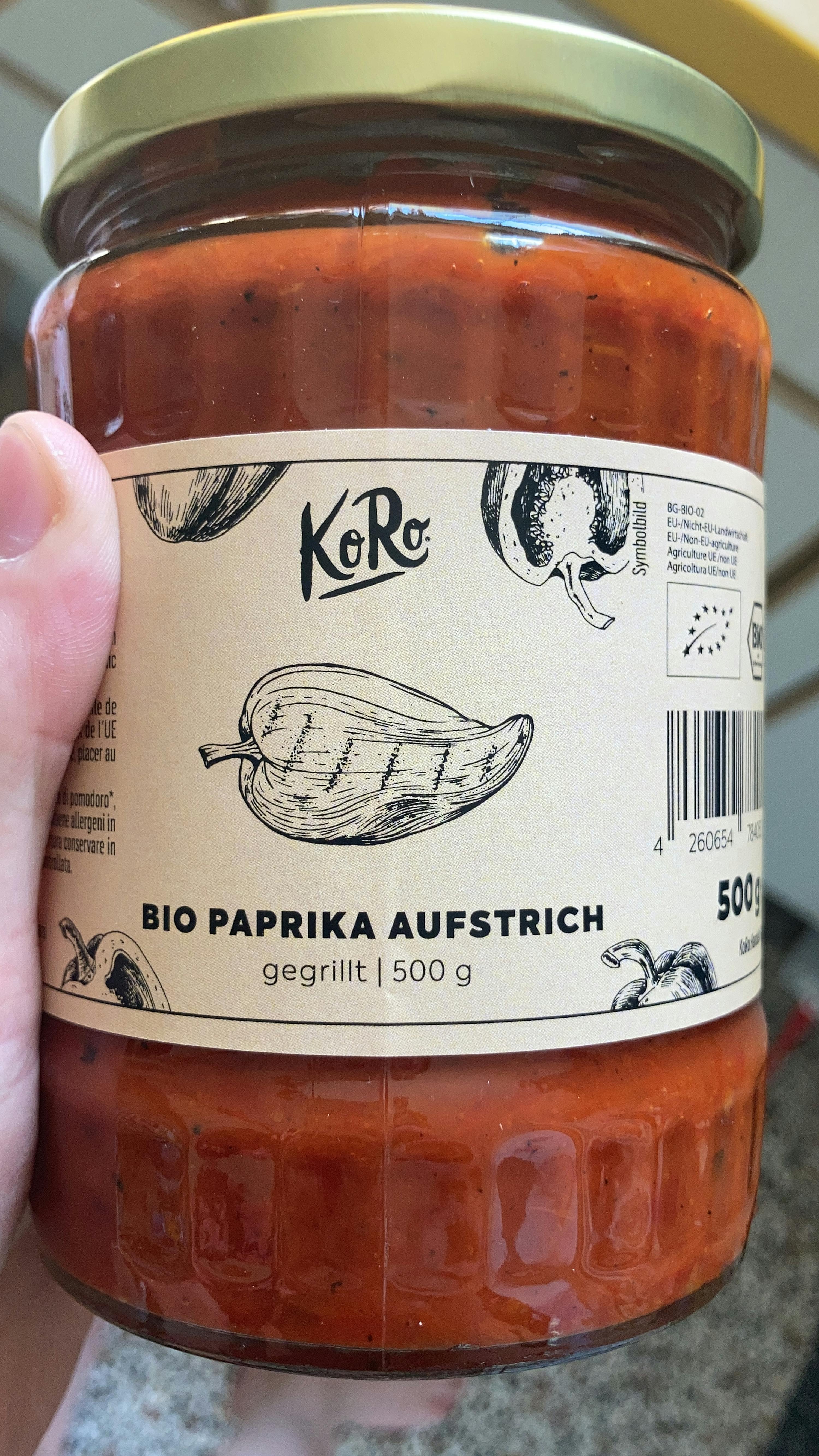 une personne tient un bocal en verre de paprika bio