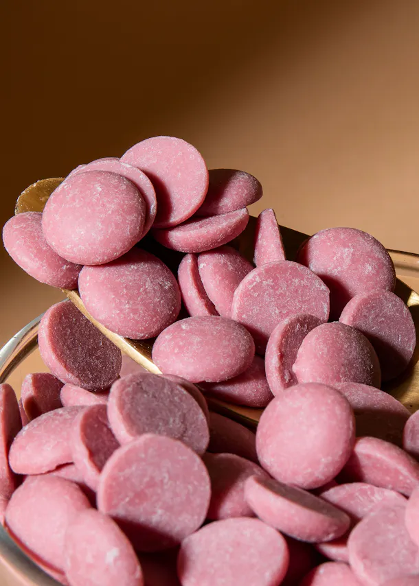 ein Haufen rosa Schokoladenscheiben auf einem Tisch