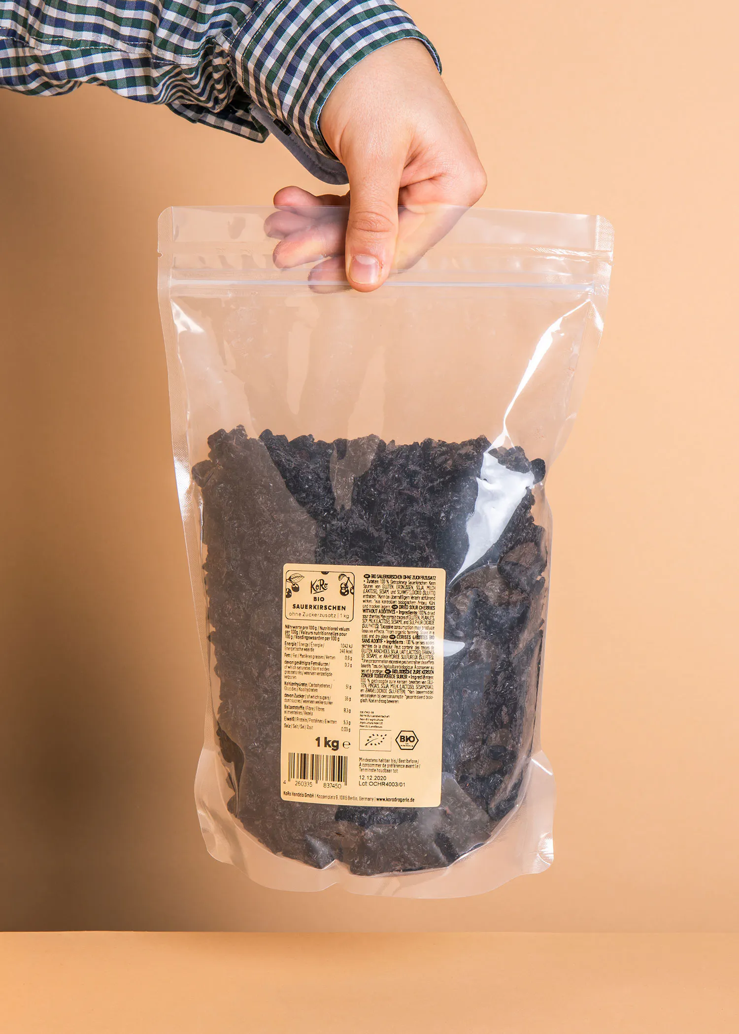 une personne tient un sac en plastique de raisins noirs