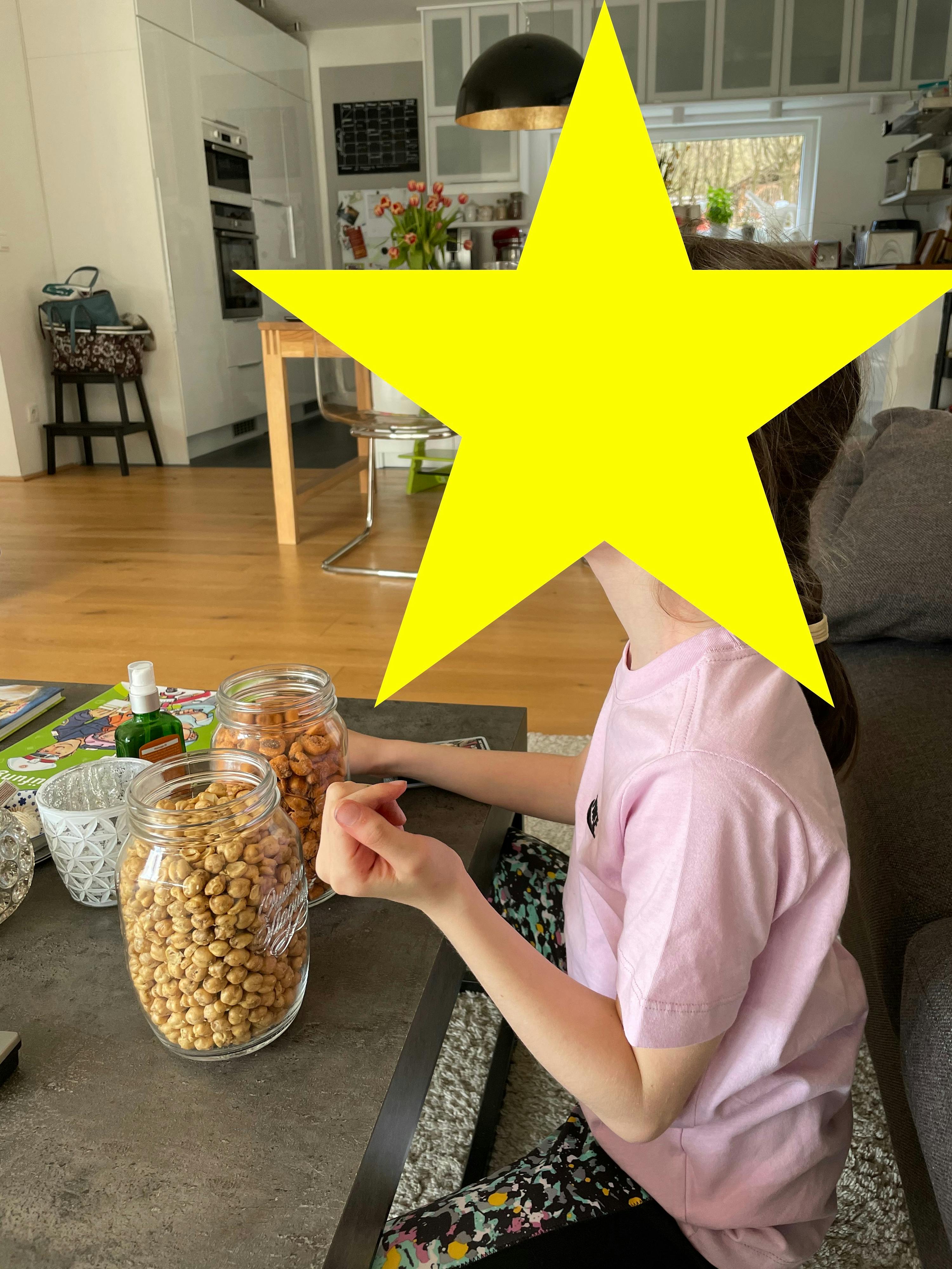 ein kleines Mädchen sitzt auf einem Tisch mit einem gelben Stern darüber