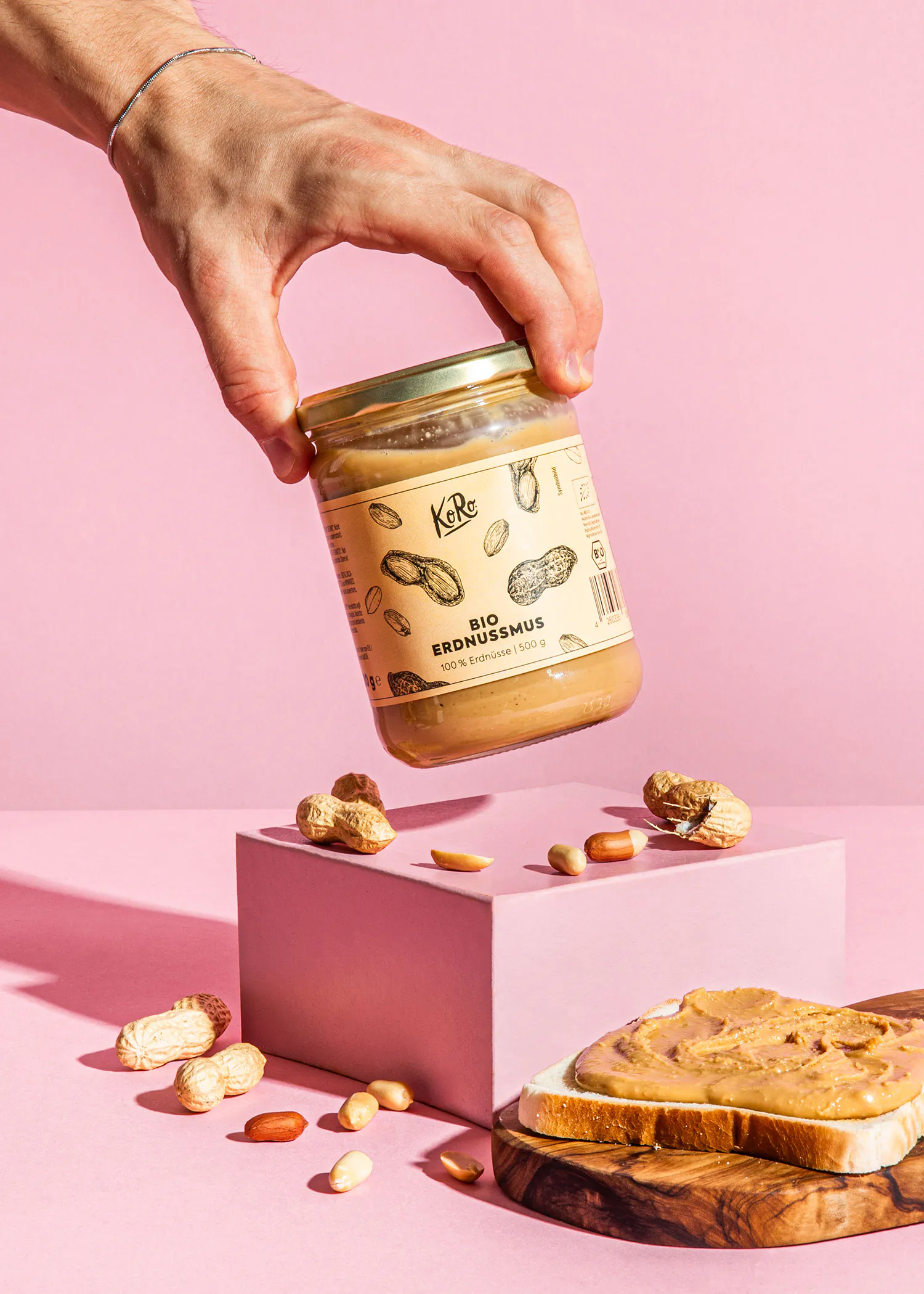 une personne tient un bocal de beurre d' arachide bio