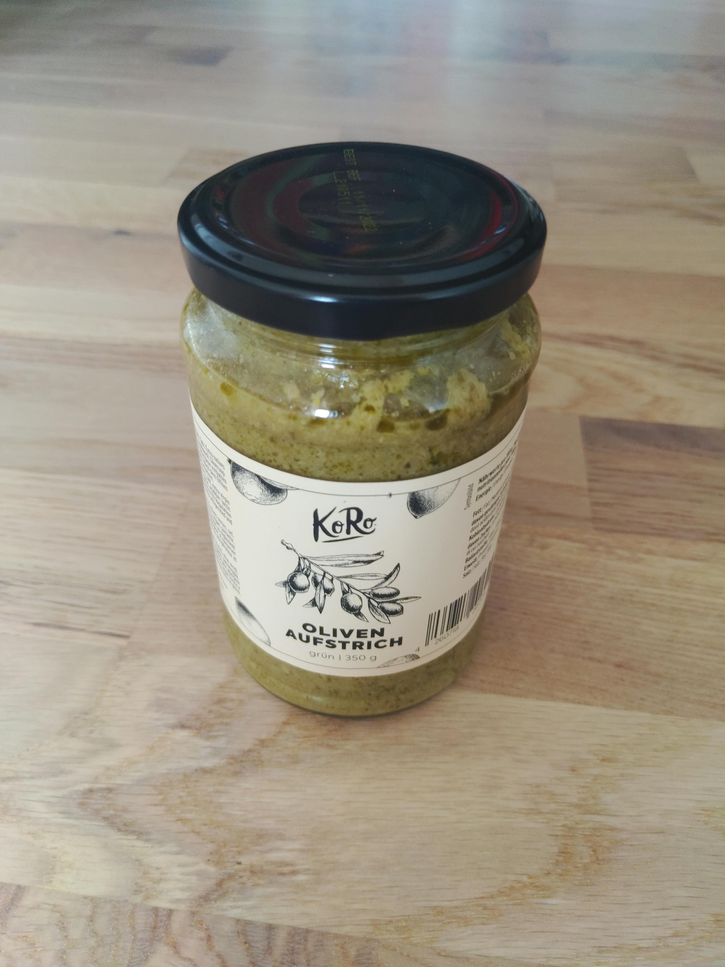a jar of oliven ausstrich is on a wooden table