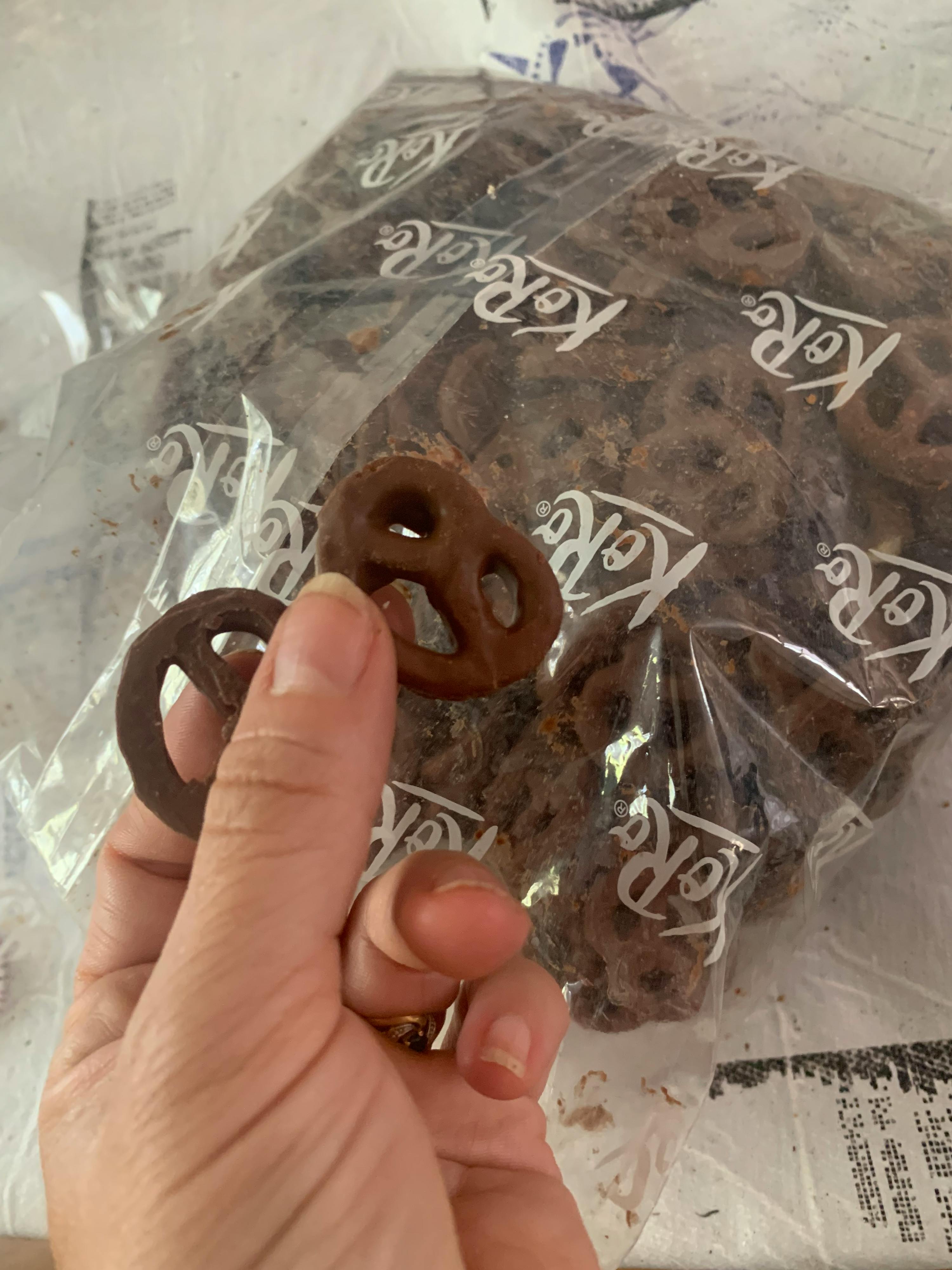 eine Person hält einen Schokoladenkringel in der Hand