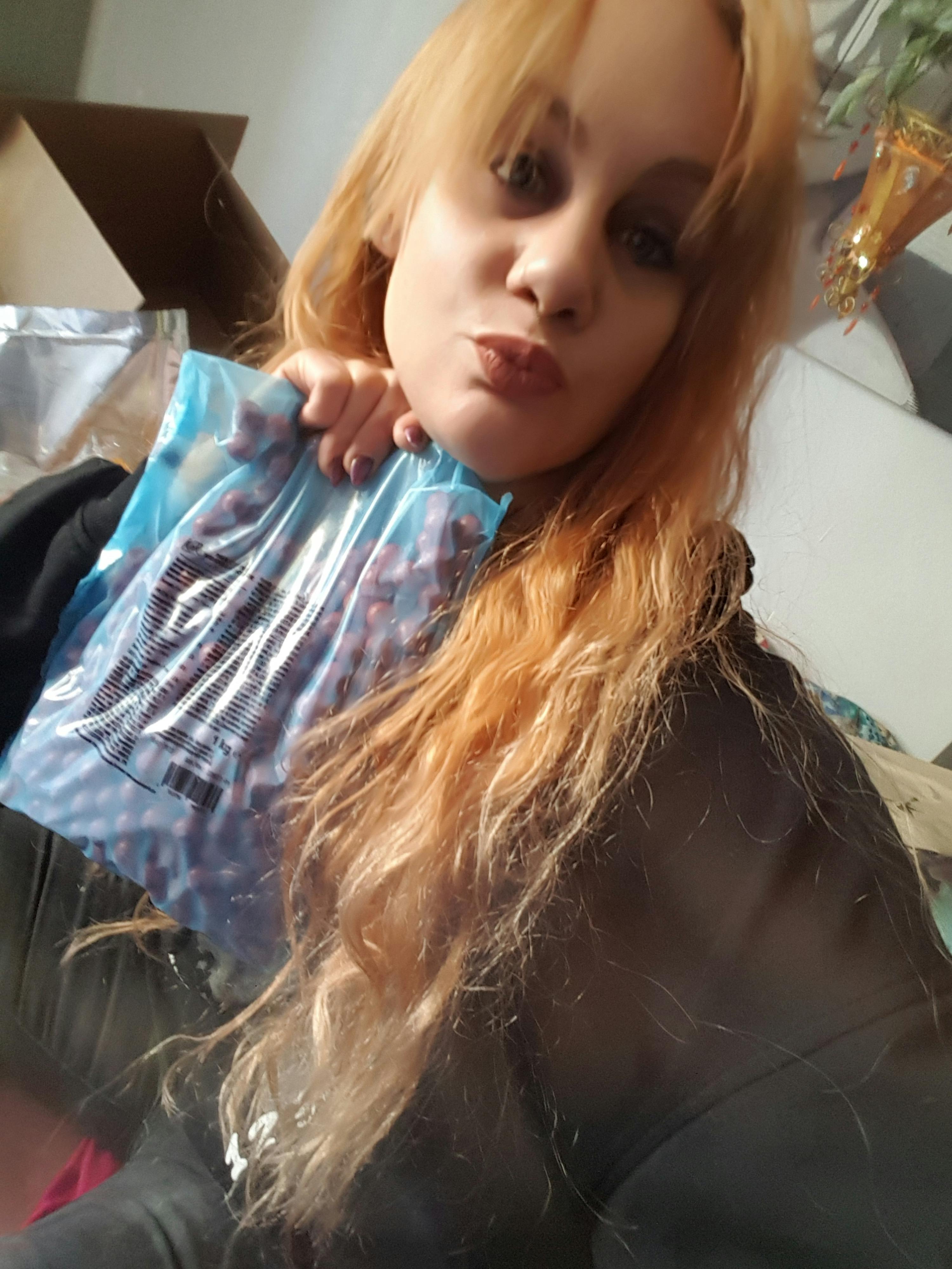 ein kleines Mädchen hält einen blauen Plastikbeutel mit der Aufschrift " snickers " darauf