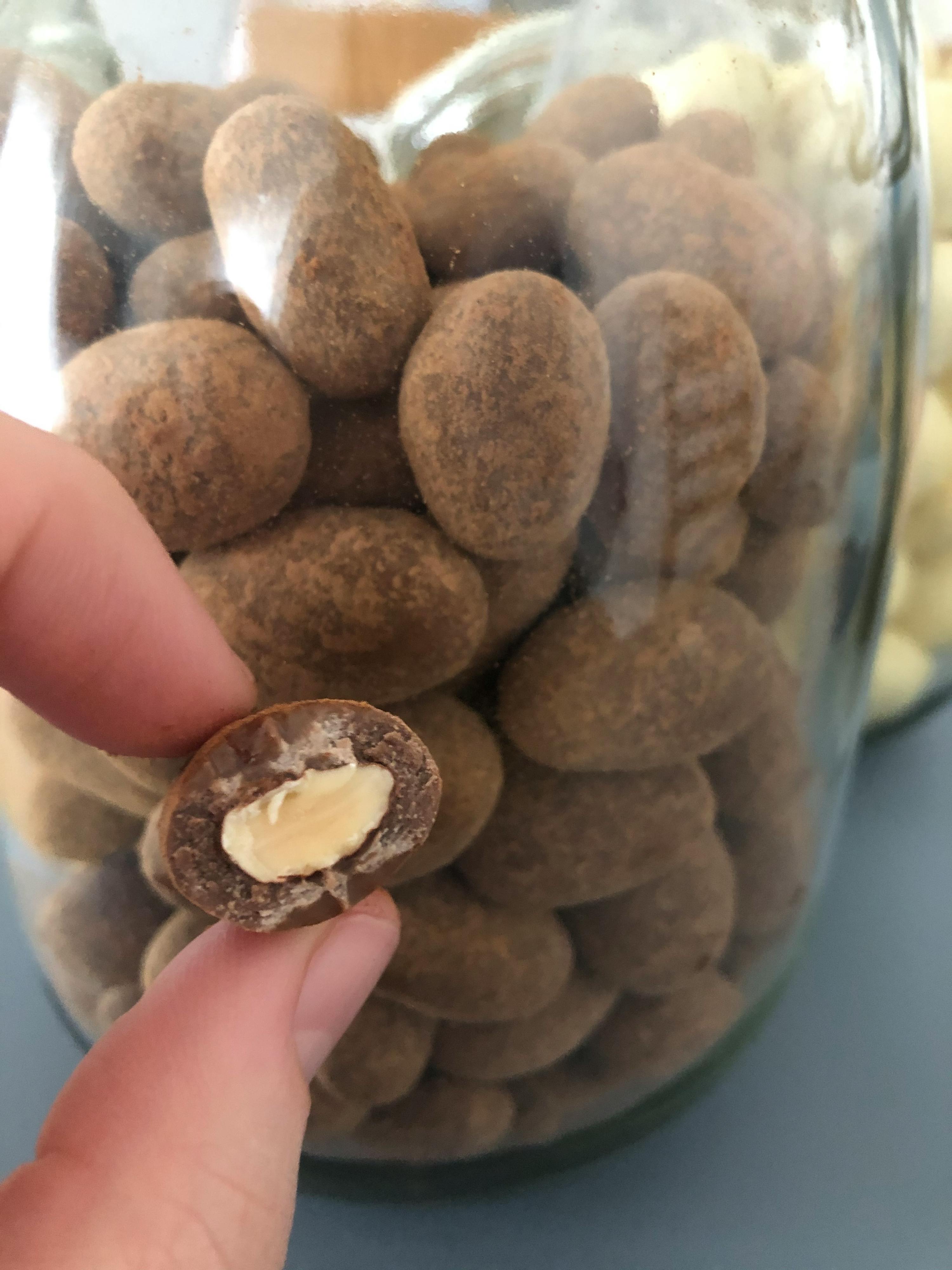 eine Person hält einen Schokoladenmantel mit einer Erdnuss darin