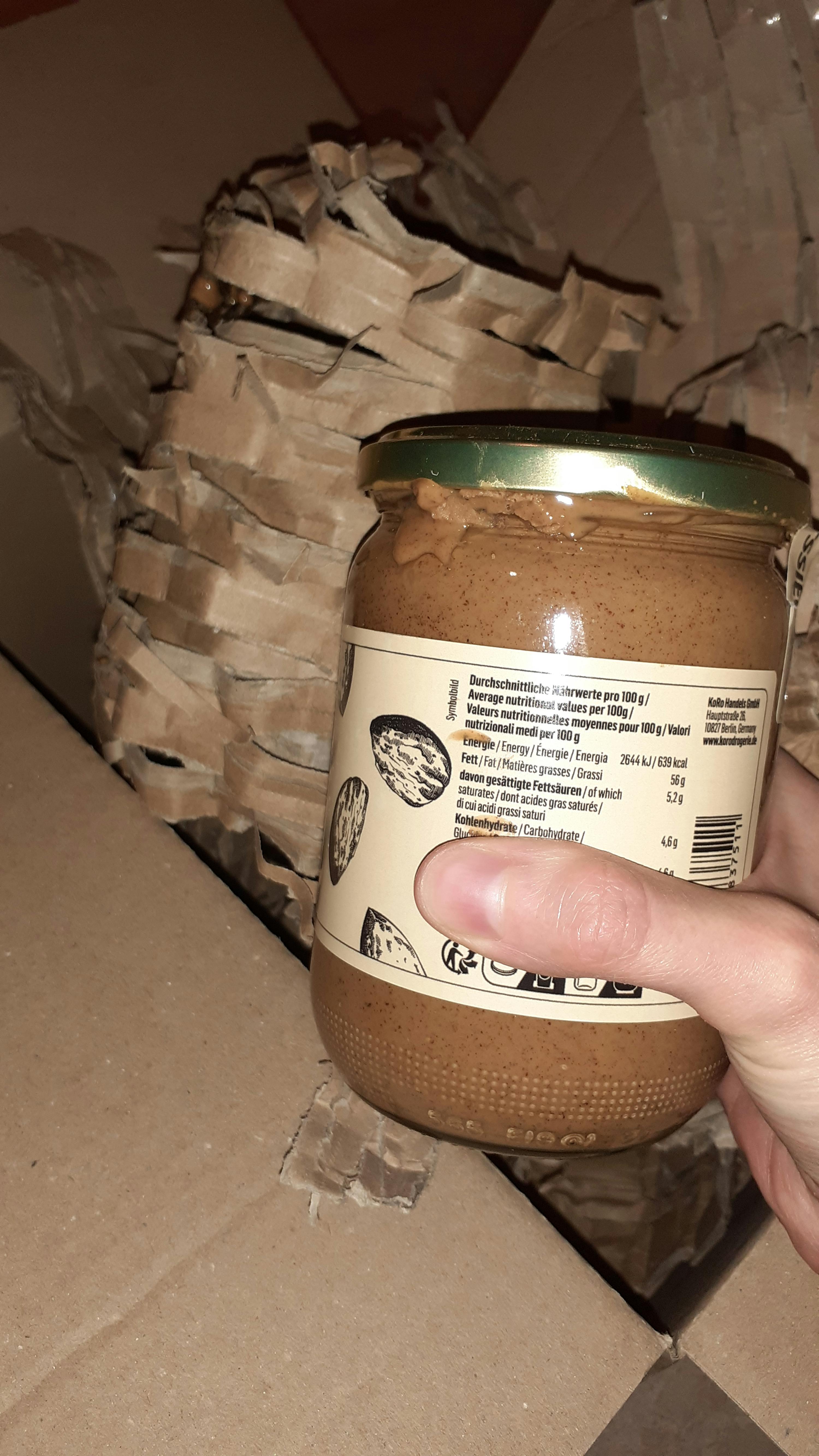 eine Person hält ein Glas Erdnussbutter in einer Schachtel