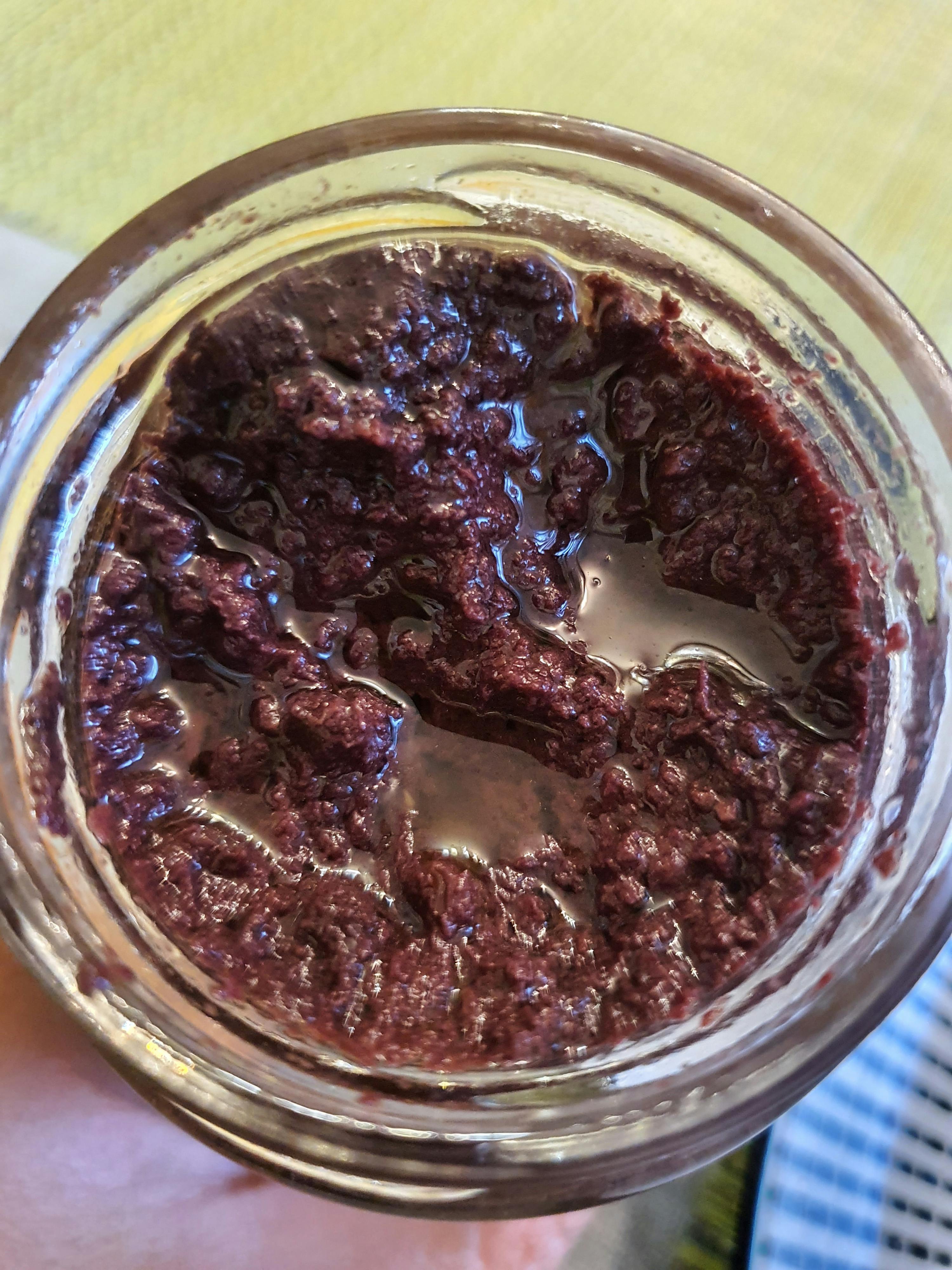 eine Person hält ein Glas gefüllt mit einem dunklen Flüssigkeit