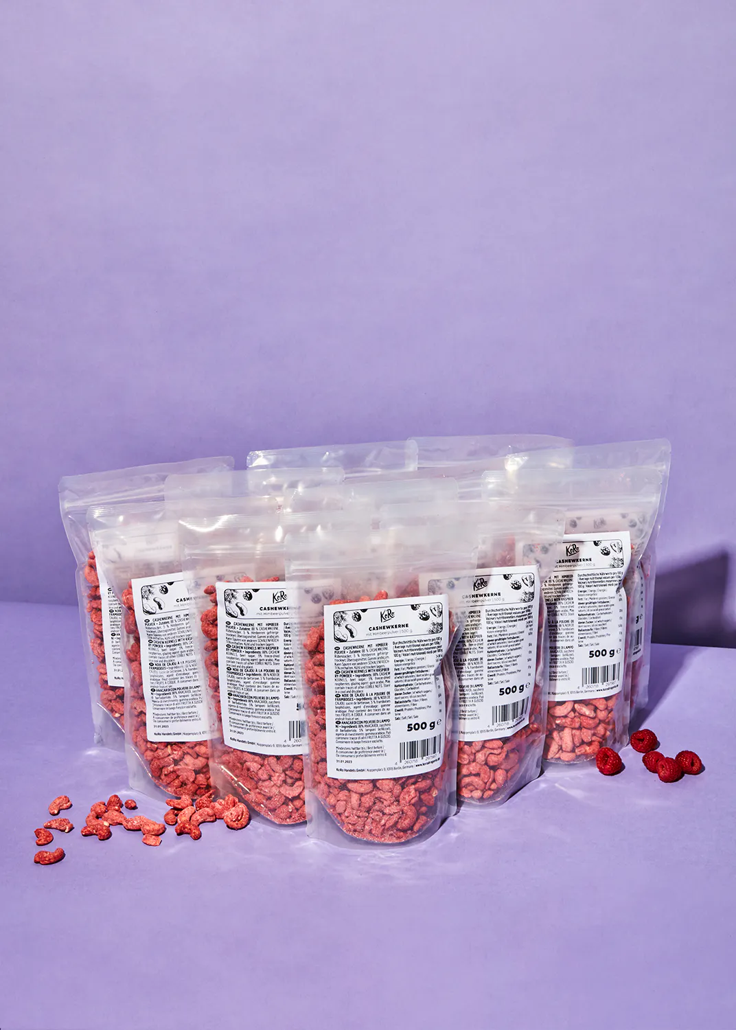 a bunch of bags of nuts are lined up on a purple surface