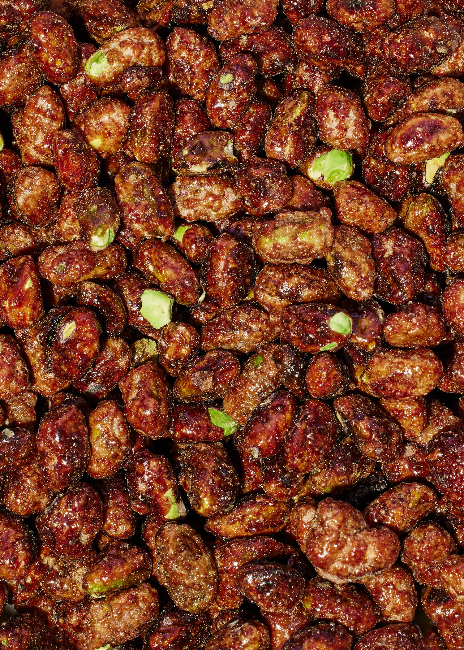 un tas de cacahuètes avec des pistaches visibles