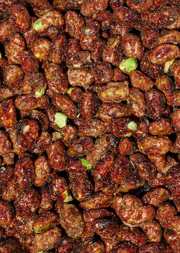 un tas de cacahuètes avec des pistaches visibles