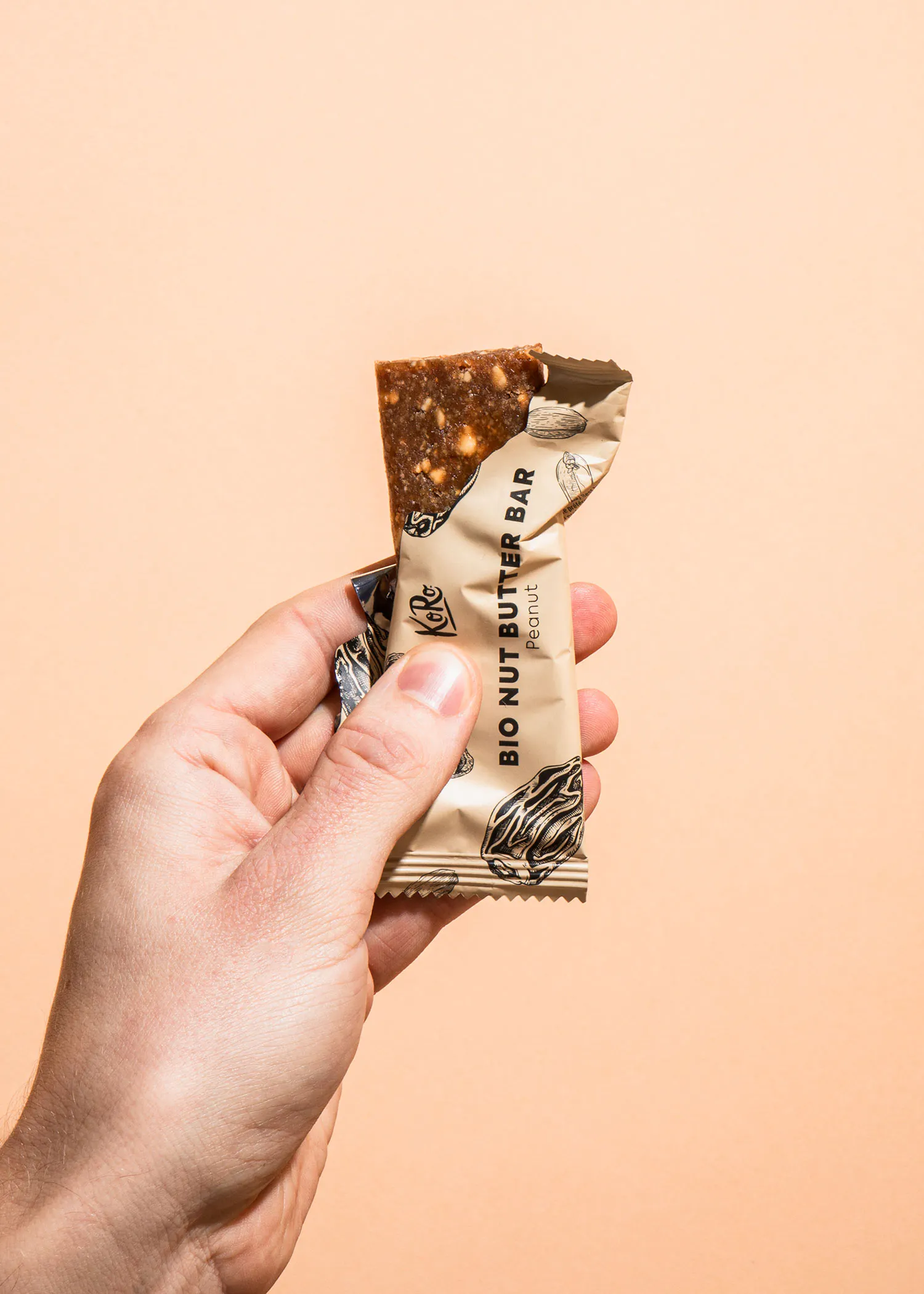 une personne tient une barre de beurre de noix bio dans sa main