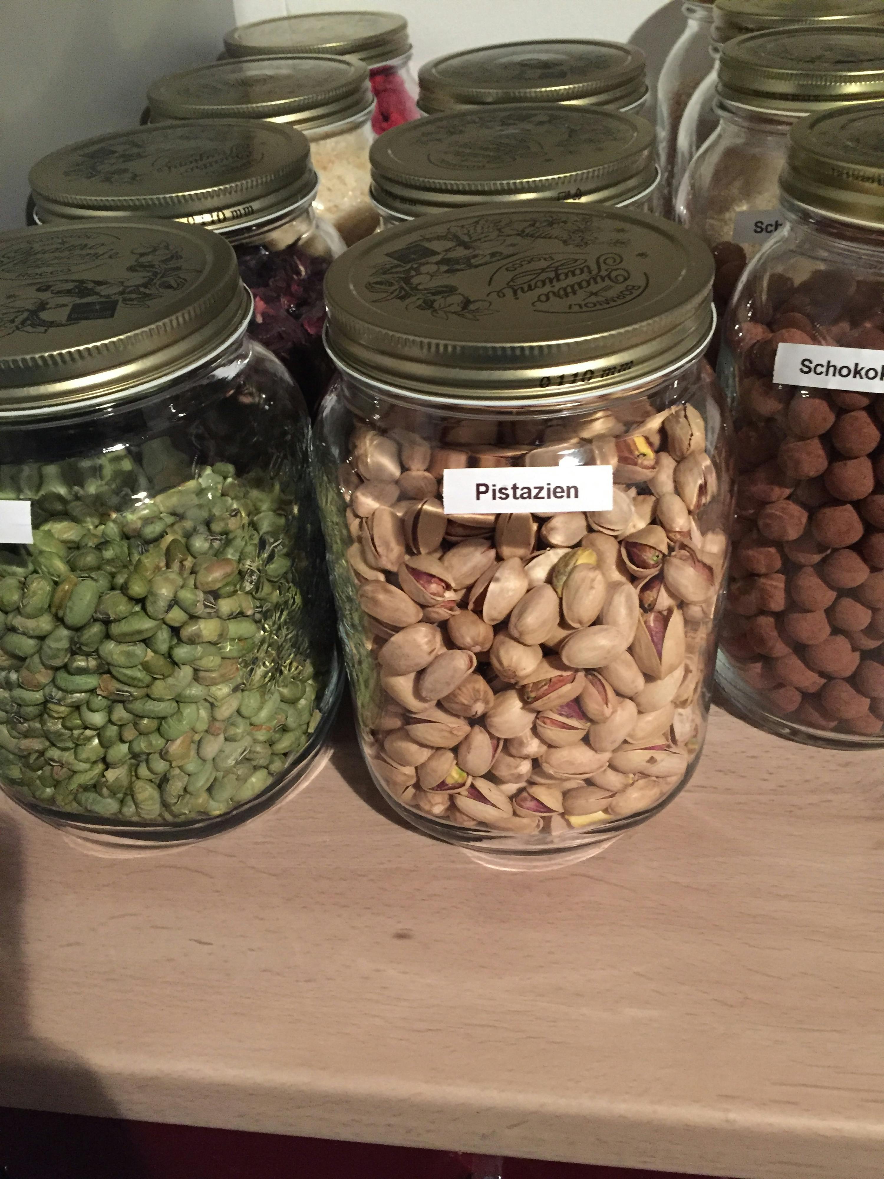 a jar of pistazien nuts sits next to a jar of hazelnuts