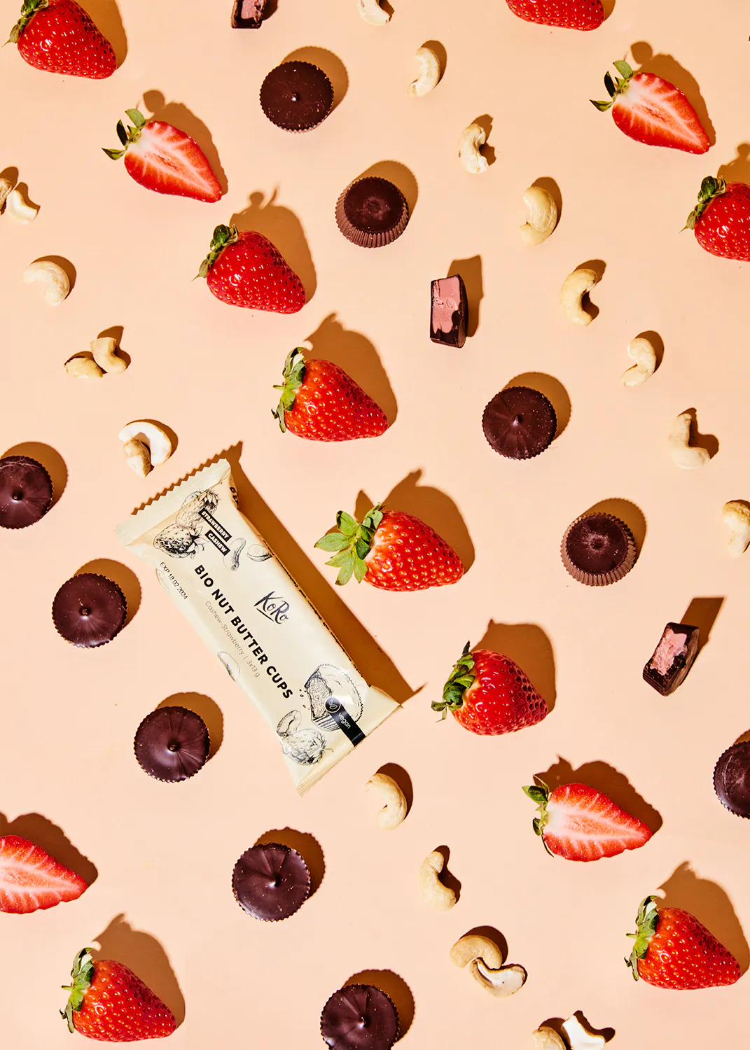 une barre de beurre de cacahuète bio est entourée de fraises et de noix