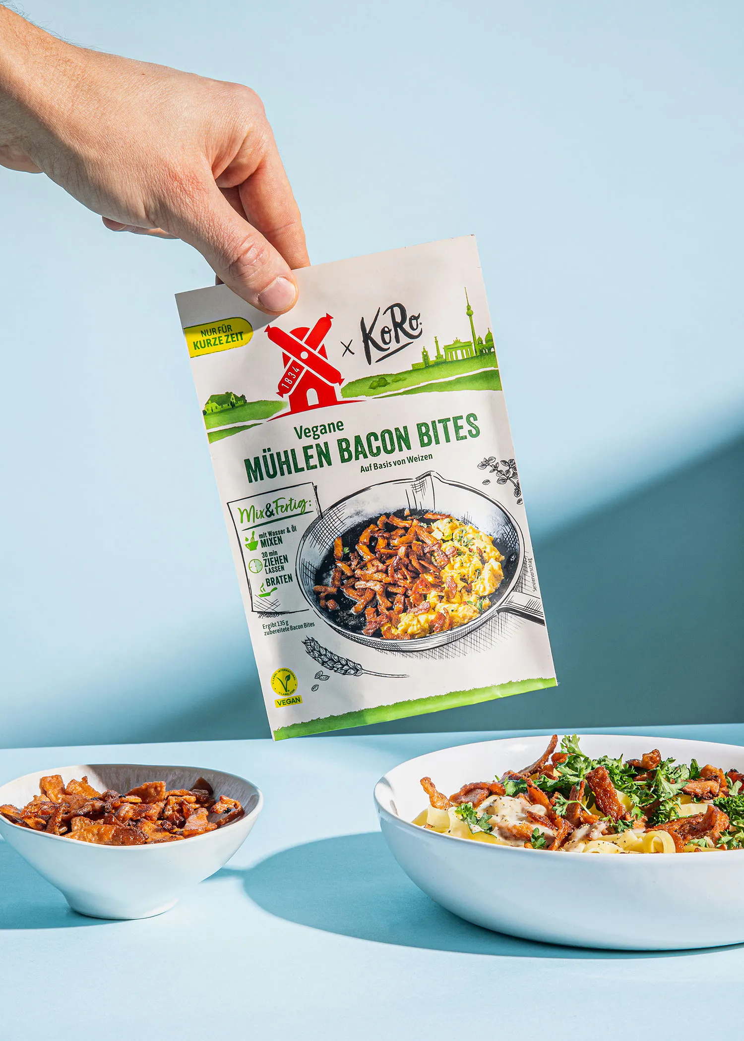a person is holding a bag of vegan bacon bites