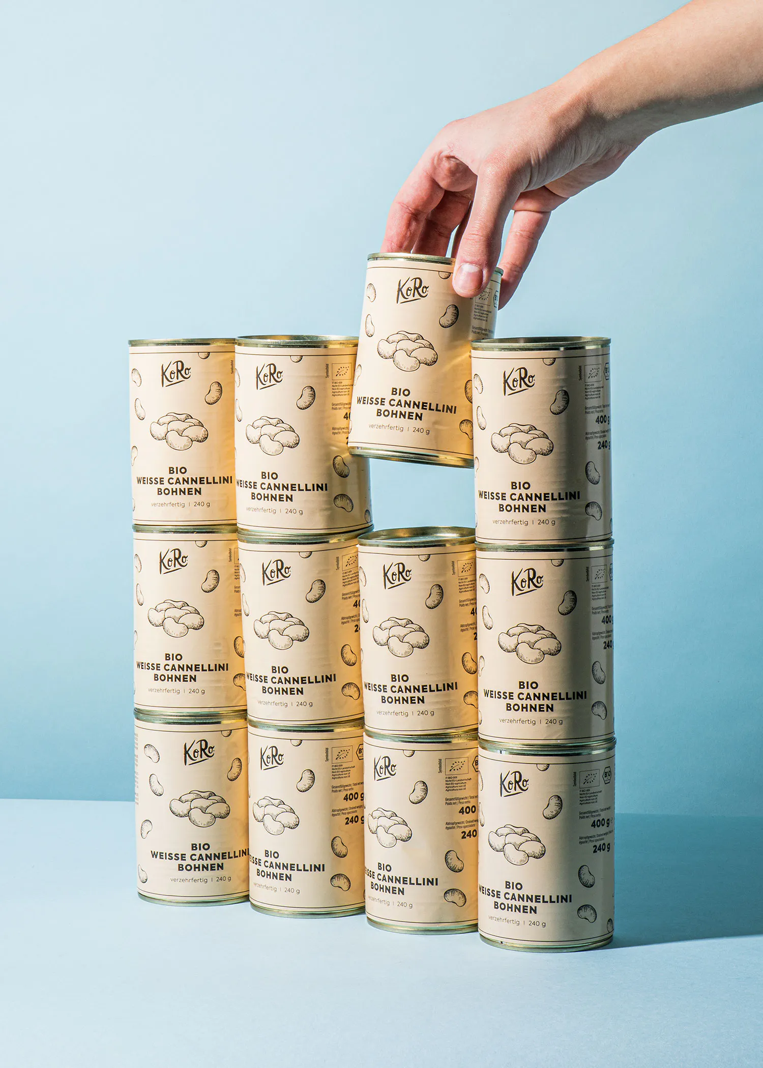 a hand reaches for a can of weisse cannellini bohnen