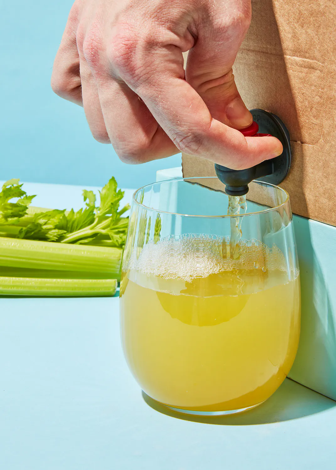 una persona vierte un líquido amarillo en un vaso