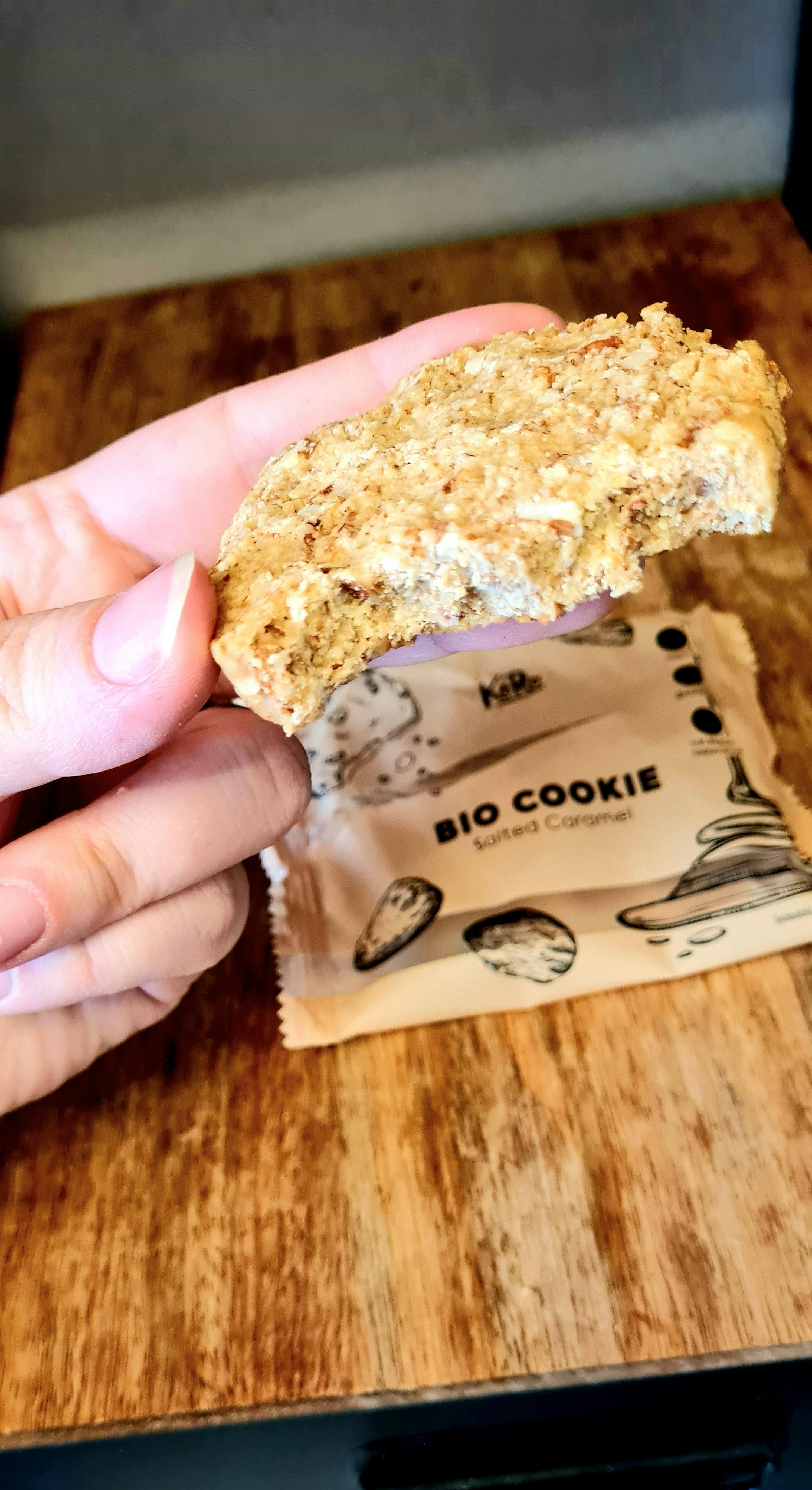 a person is holding a bite of a bio cookie