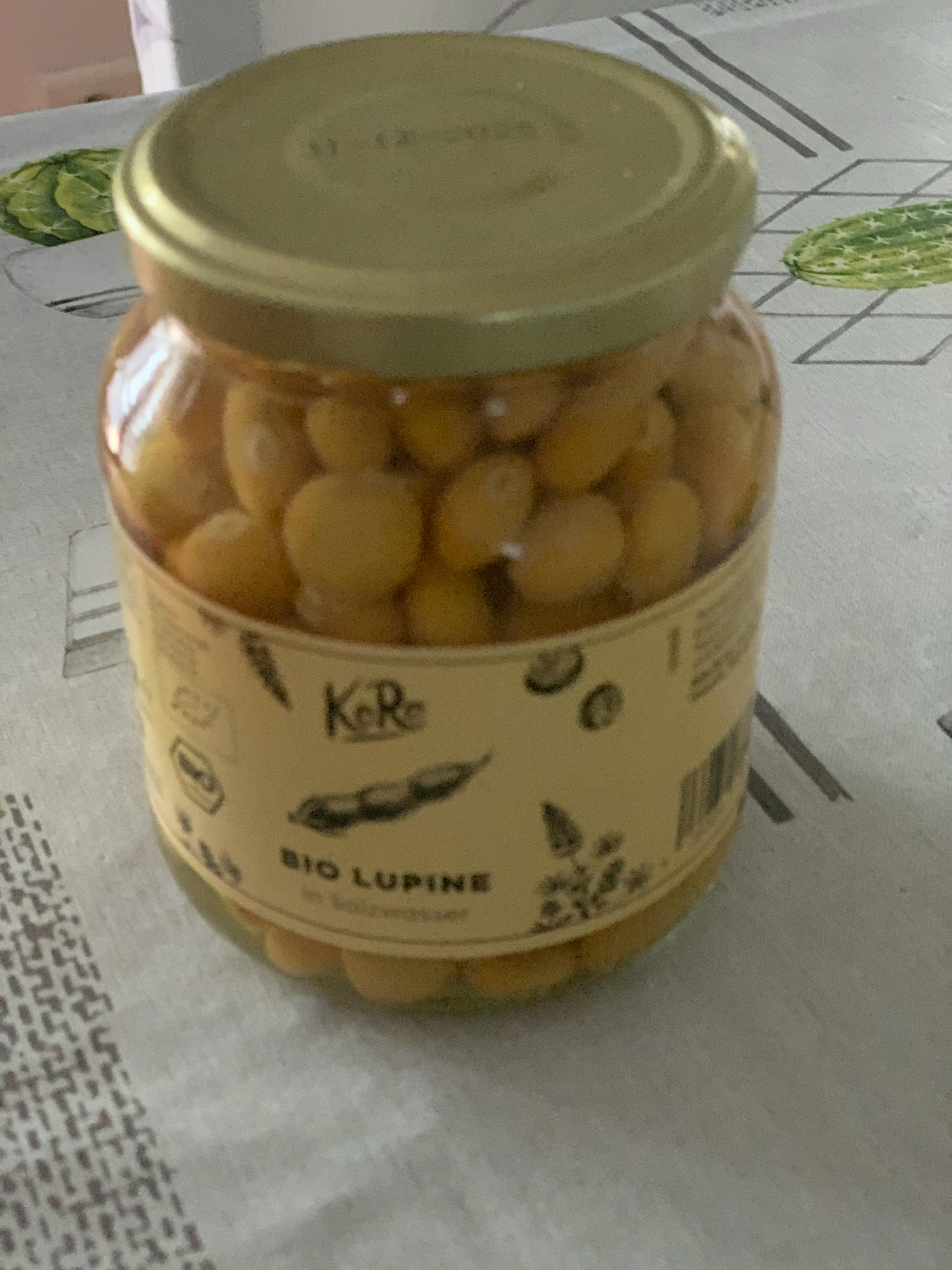 un bocal en verre rempli de haricots bio lupine sur une table
