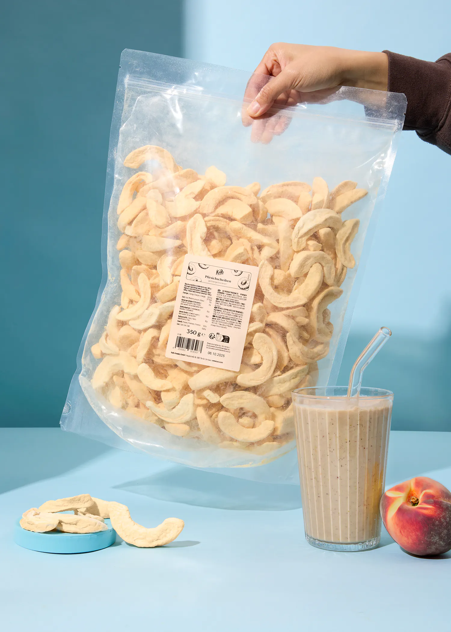 eine Person hält einen Plastiksack mit getrockneten Äpfeln in der Hand