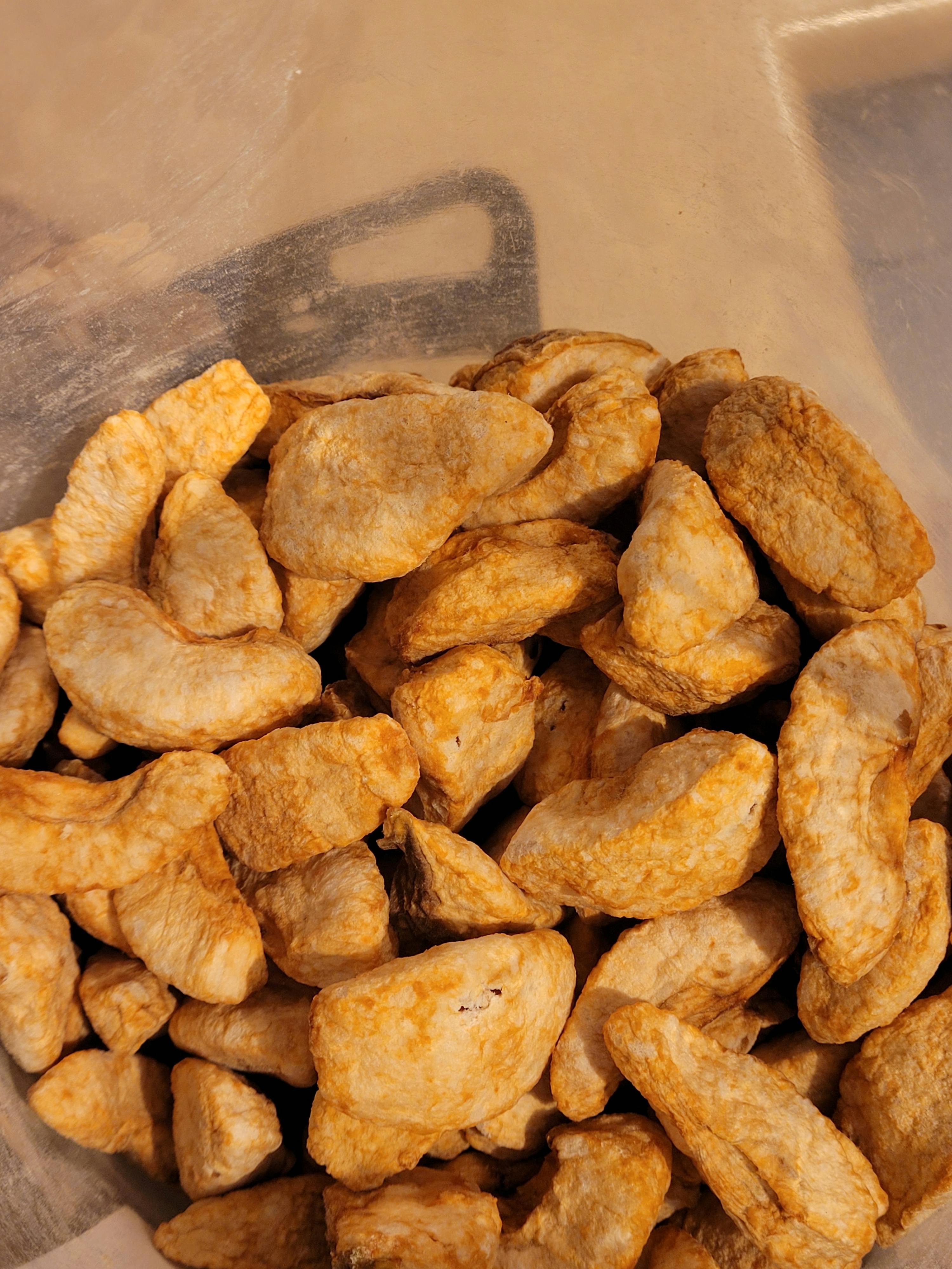 a plastic container filled with fried chicken pieces