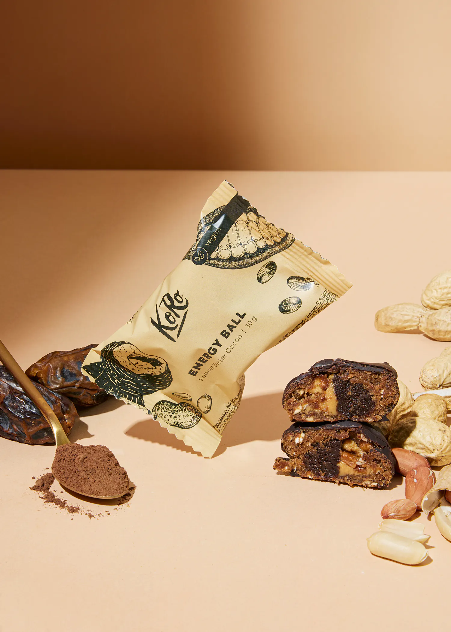 eine energiekugel mit kakaopulver und erdnüssen auf einem tisch