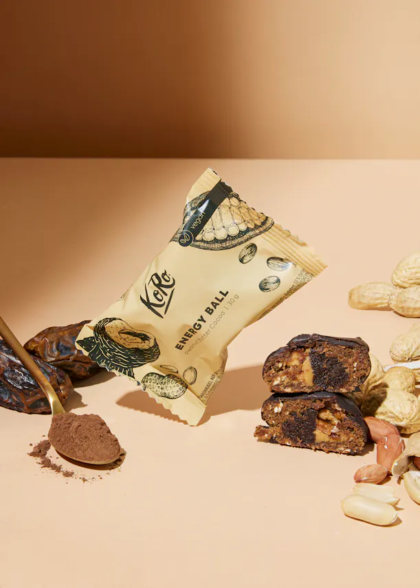 eine energiekugel mit kakaopulver und erdnüssen auf einem tisch