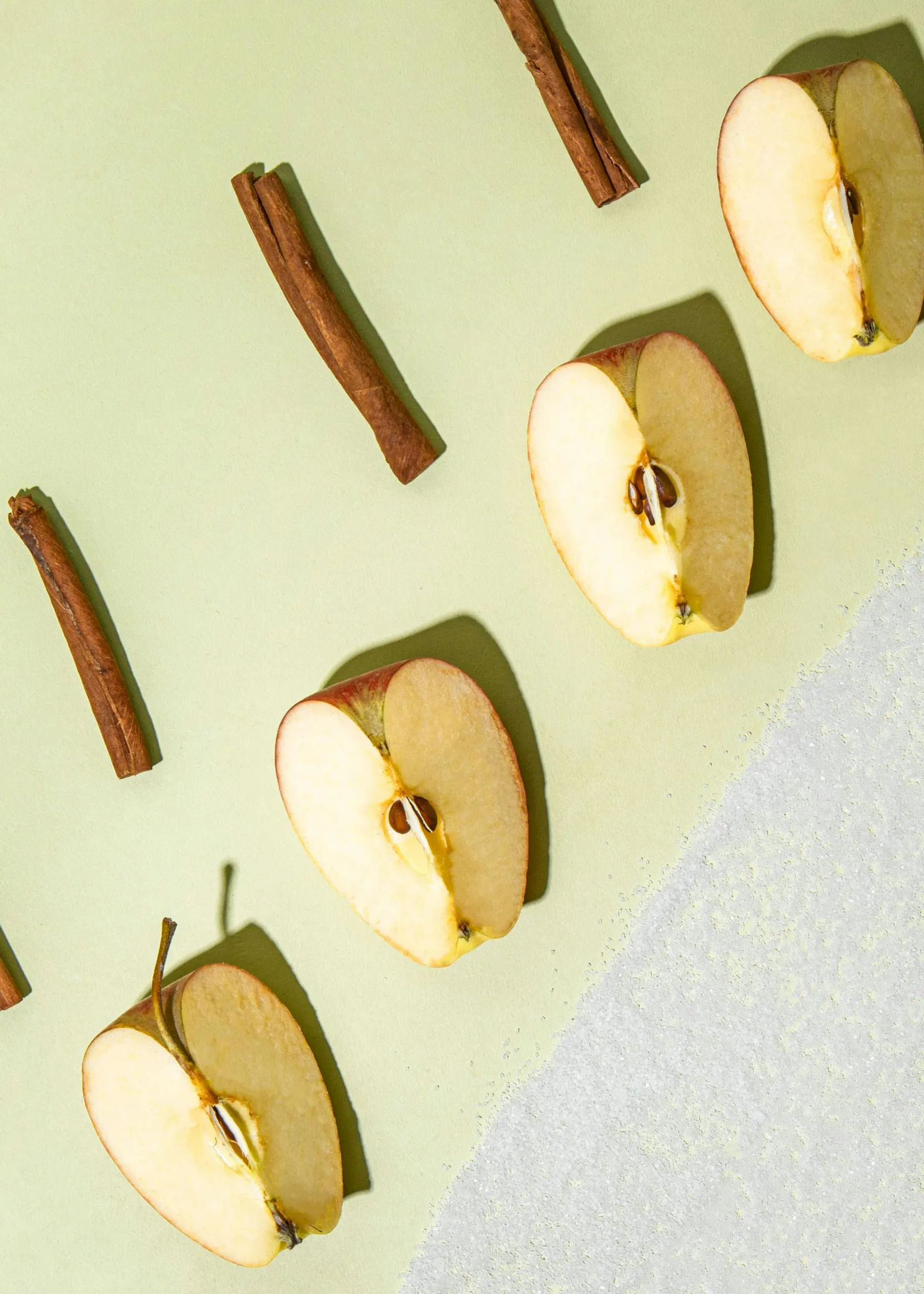 les pommes sont coupées en deux et les bâtons de cannelle sont alignés