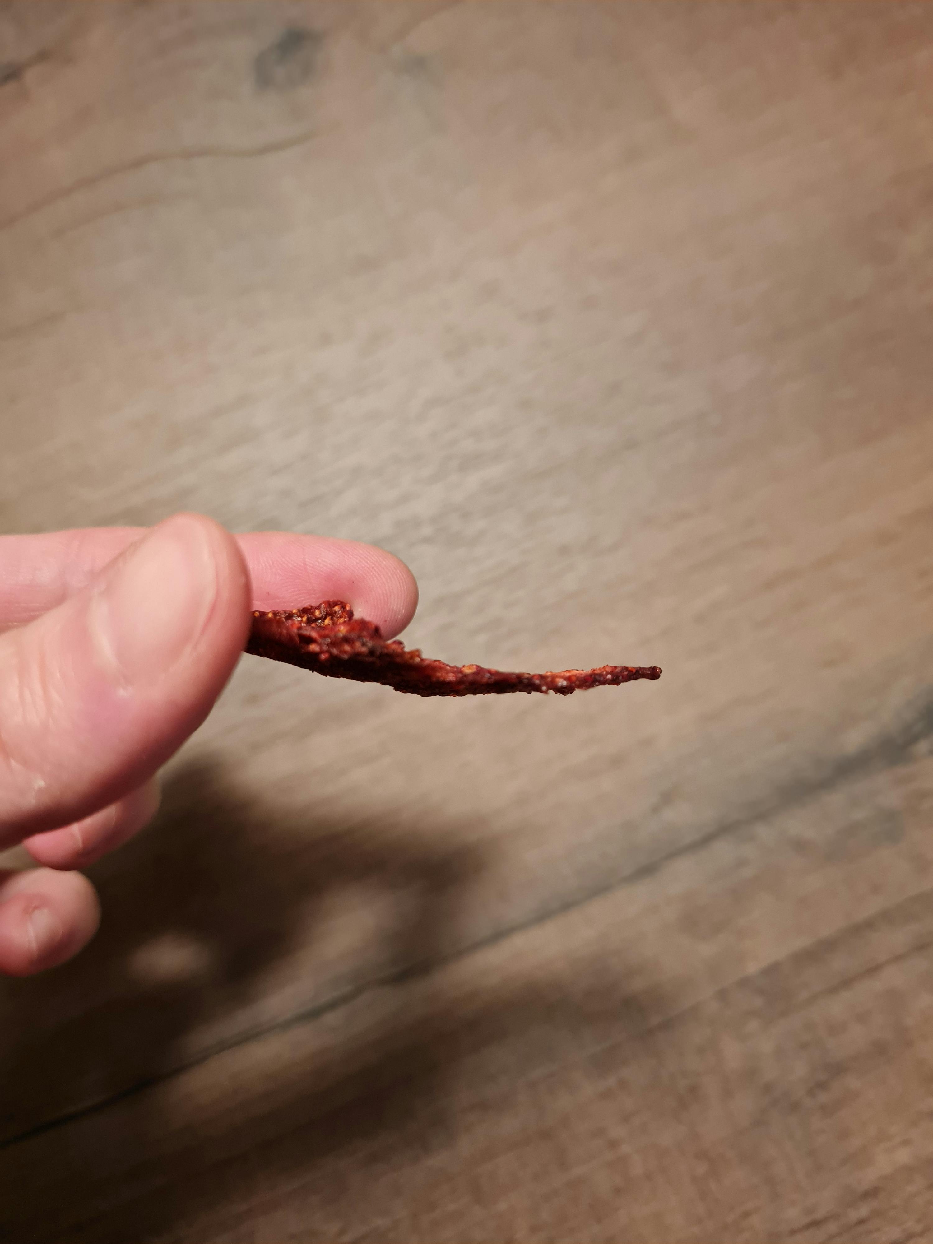 a person is holding a piece of food in their finger