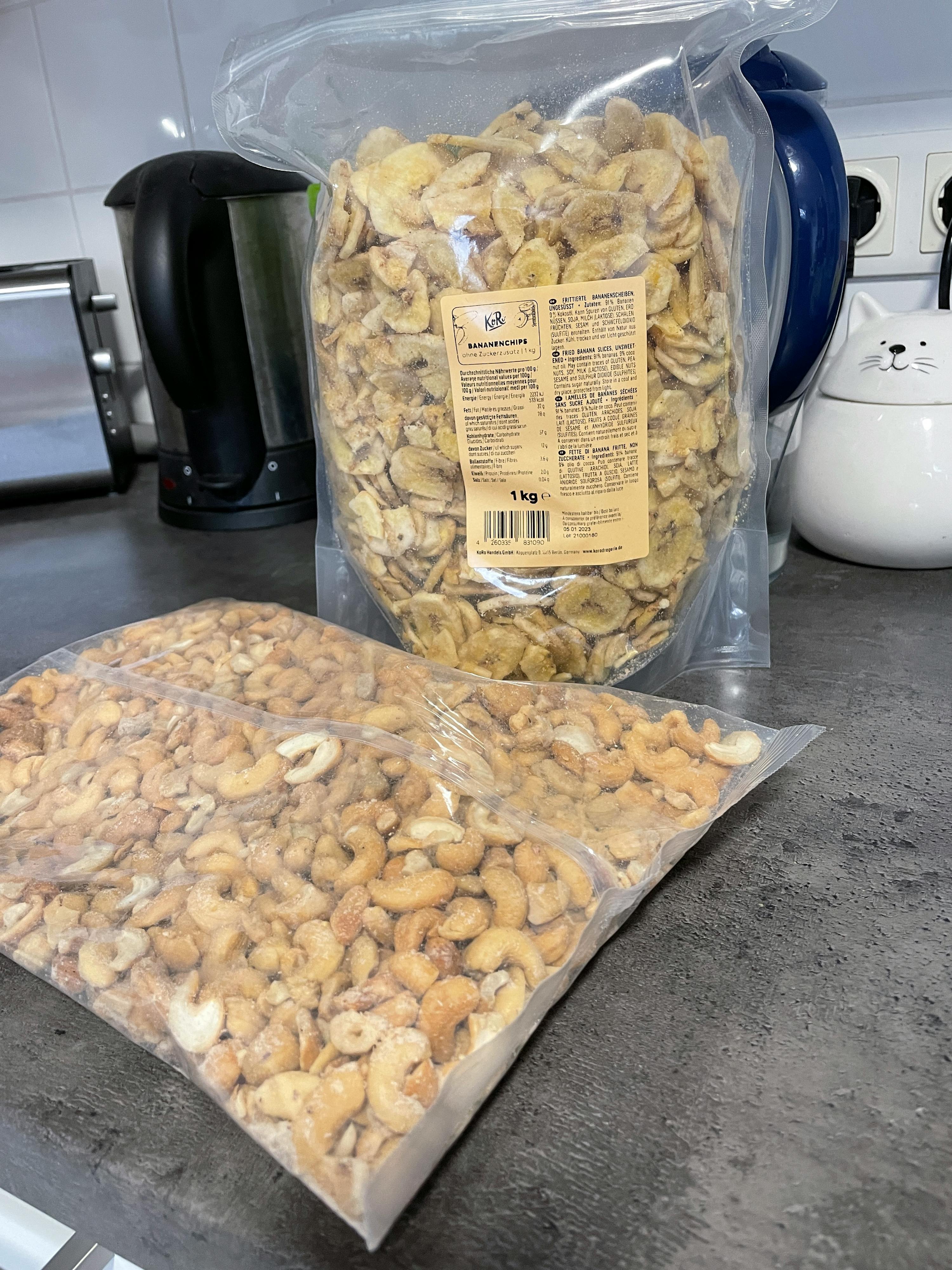 eine Tüte Bananen und eine Tüte Cashewnüsse liegen auf einem Tisch